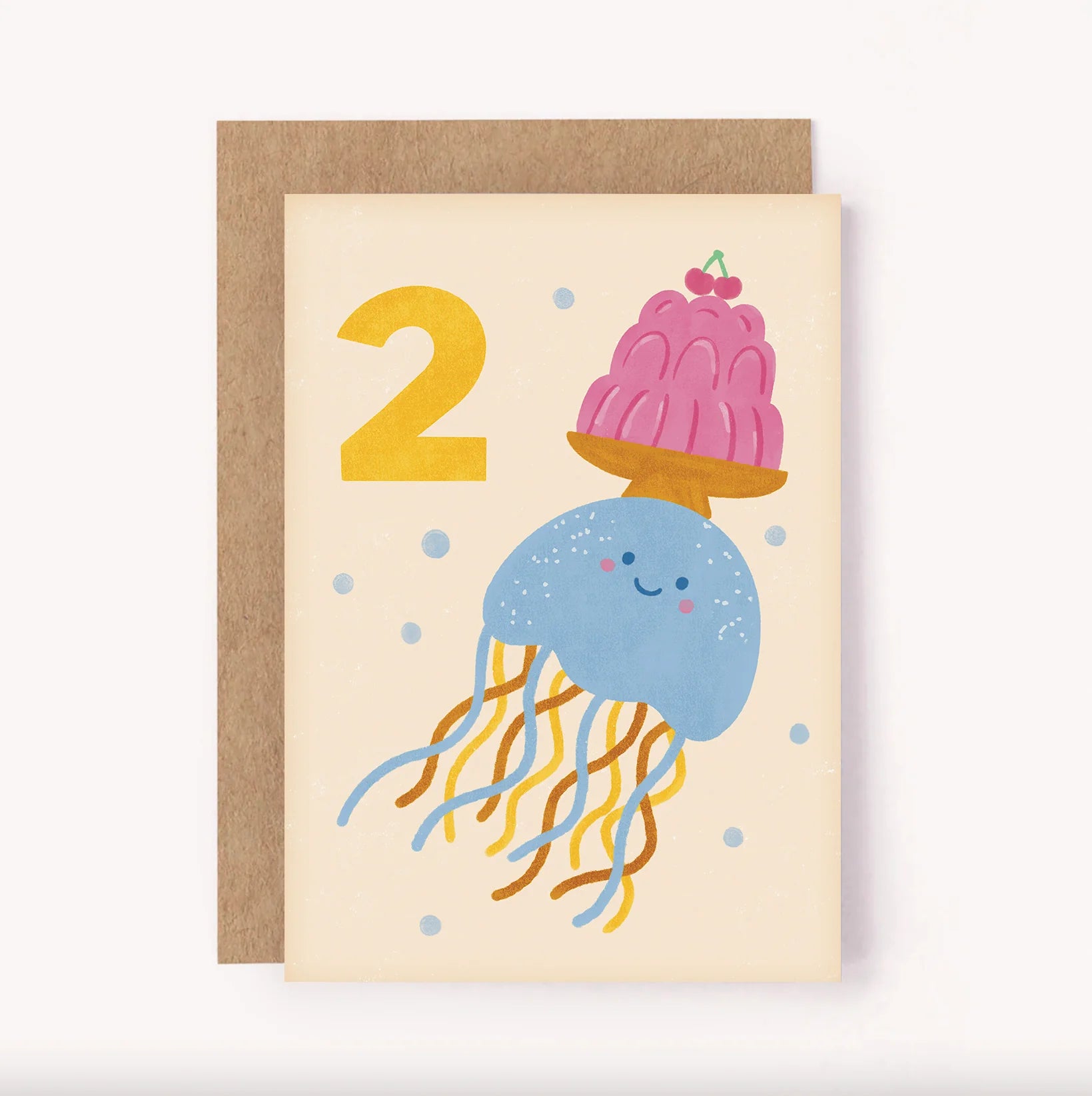 The 2nd Birthday Age Milestone Card featuring an illustrated jellyfish balancing a plate of jelly and two cherries alongside a bold hand-lettered number 2 on a soft beige background.