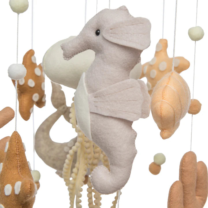 The ROOMI & ME Baby Mobile Underwater Dreaming features a handmade light gray seahorse, beige and white seashells and starfish, plus soft felt balls—perfect nursery decor for calming visual stimulation.