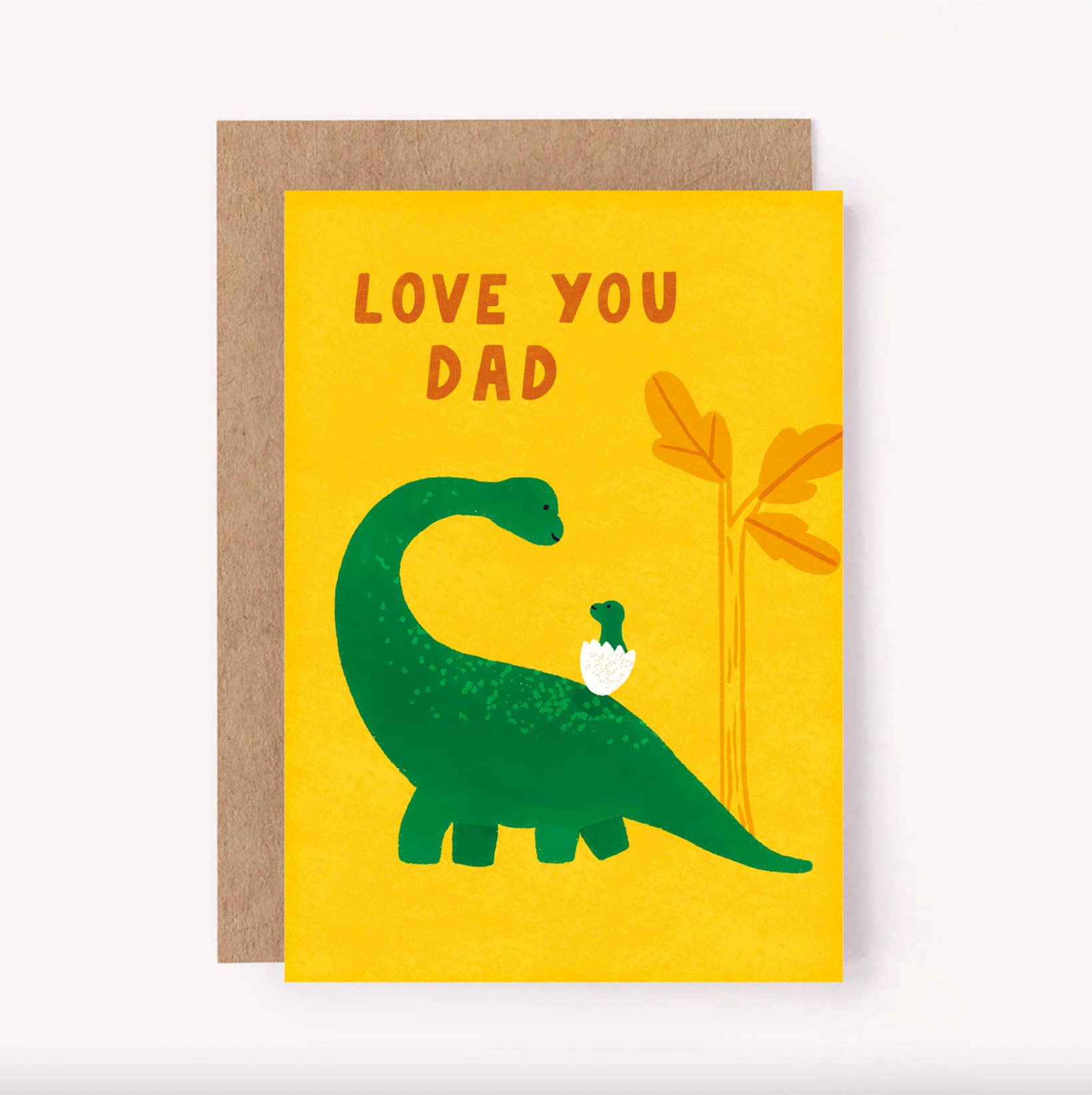 The Lauren Sissons Studio Dinosaur Dad Father’s Day Greeting Card by LAUREN SISSONS STUDIO features a big green dino carrying a small one, with "LOVE YOU DAD" above. Includes a brown envelope—perfect for Father's Day.