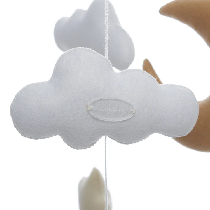 A close-up of a soft, white felt cloud hanging from the Roomi & Me - Baby Mobile Starry Night by ROOMI & ME, with blurred felt clouds and a crescent moon in the background, designed for gentle visual stimulation.