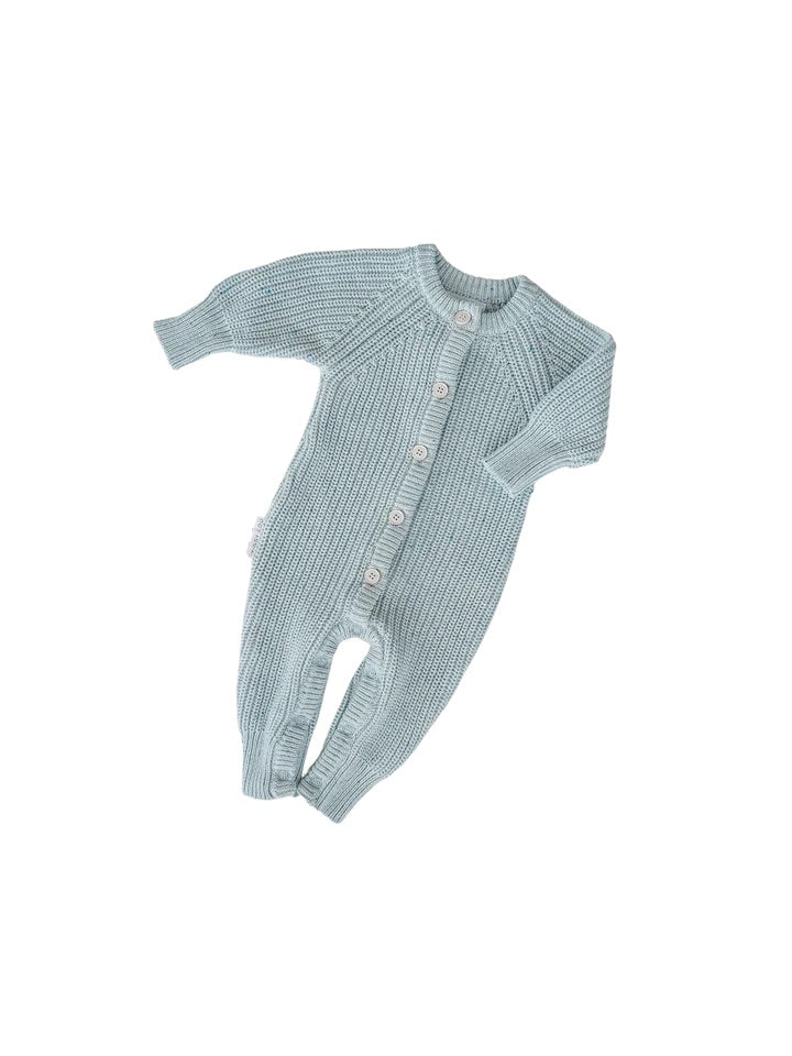 The Ziggy Lou - Classic Knit Romper Aero Fleck by ZIGGY LOU is a light blue long-sleeve, long-leg knitted romper with white buttons down the front and at the bottom for easy fastening, shown on a white background.