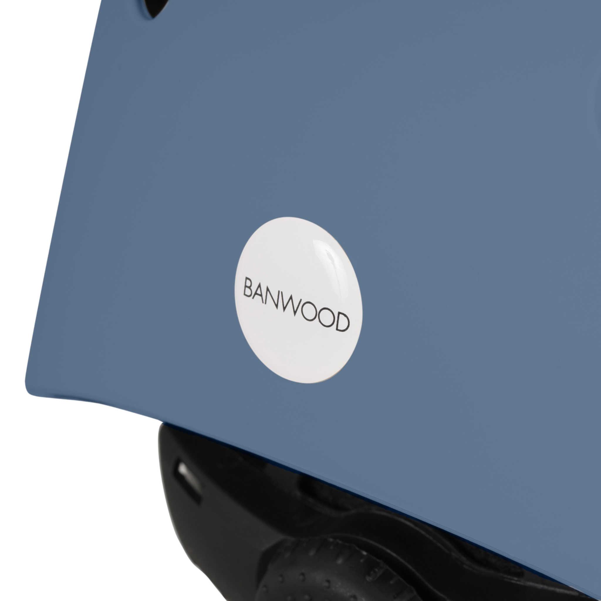 Close-up of the Banwood - Eco Helmet Deep Sea, featuring a smooth blue design with a white logo displaying "BANWOOD" in black. This sustainable helmet is crafted from recycled materials, beautifully showcasing its eco-friendly design.