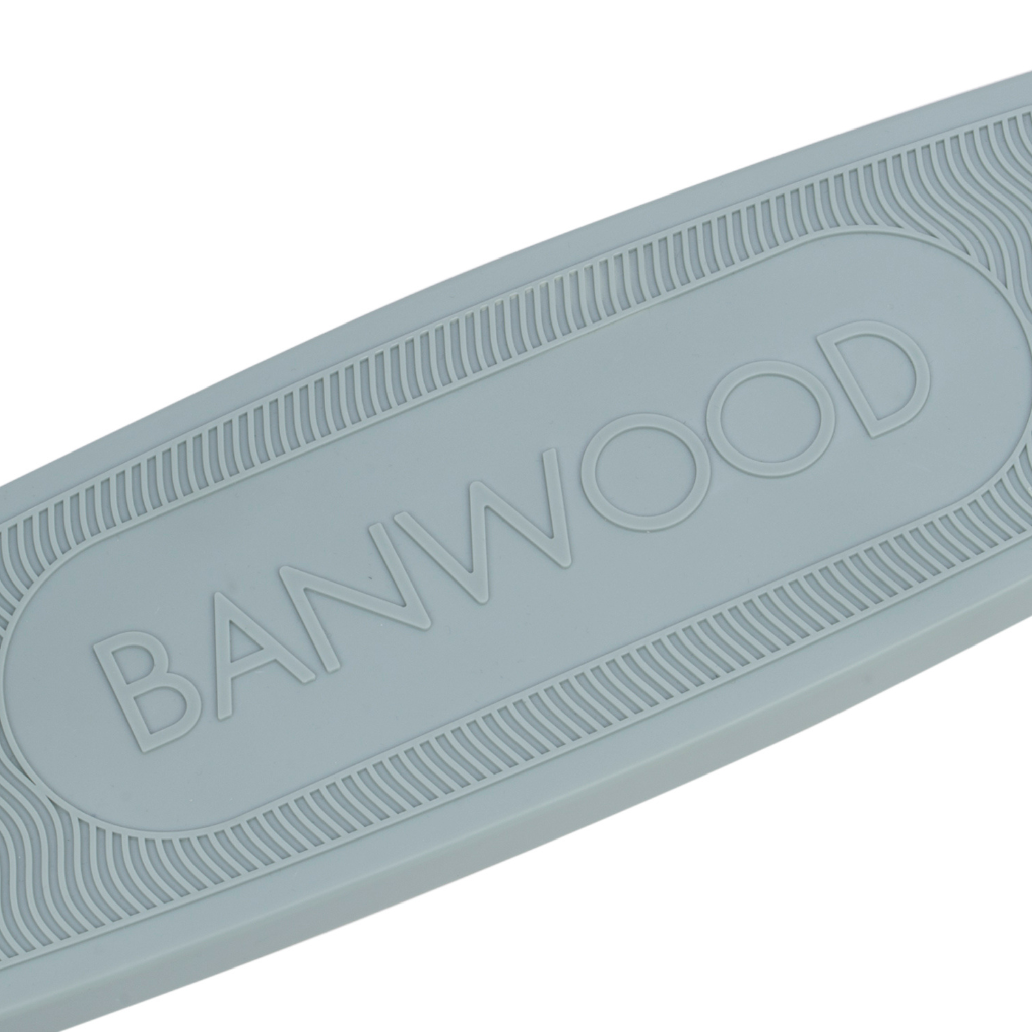 Close-up of a light gray surface featuring the embossed word "BANWOOD." Made from recycled plastic, it embodies sustainability. The edges display a pattern of repeating lines, reflecting the eco-friendly ethos of Banwood's Eco Scooter Teal.