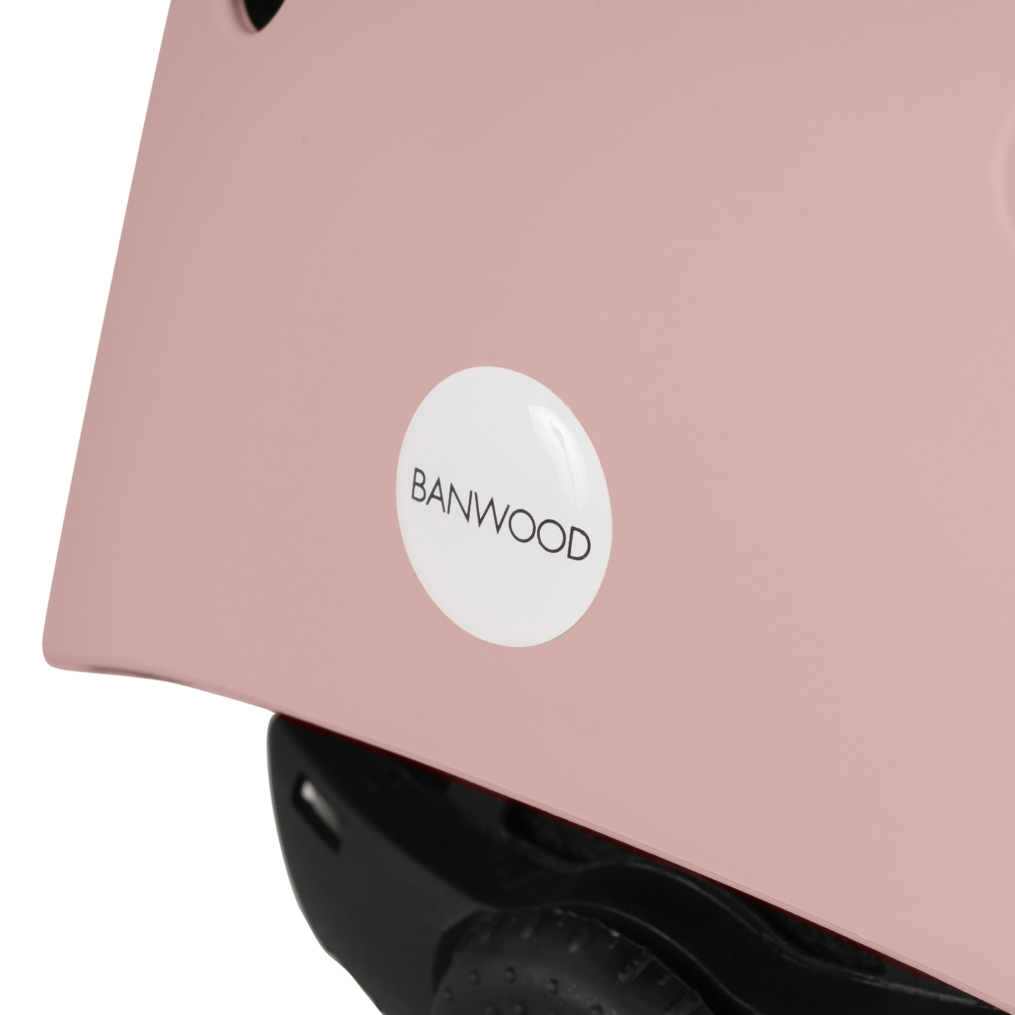 Close-up of a Banwood - Eco Helmet Dusty Rose featuring a BANWOOD sticker, crafted from recycled materials with a black adjustable strap, highlighting safety and sustainability.