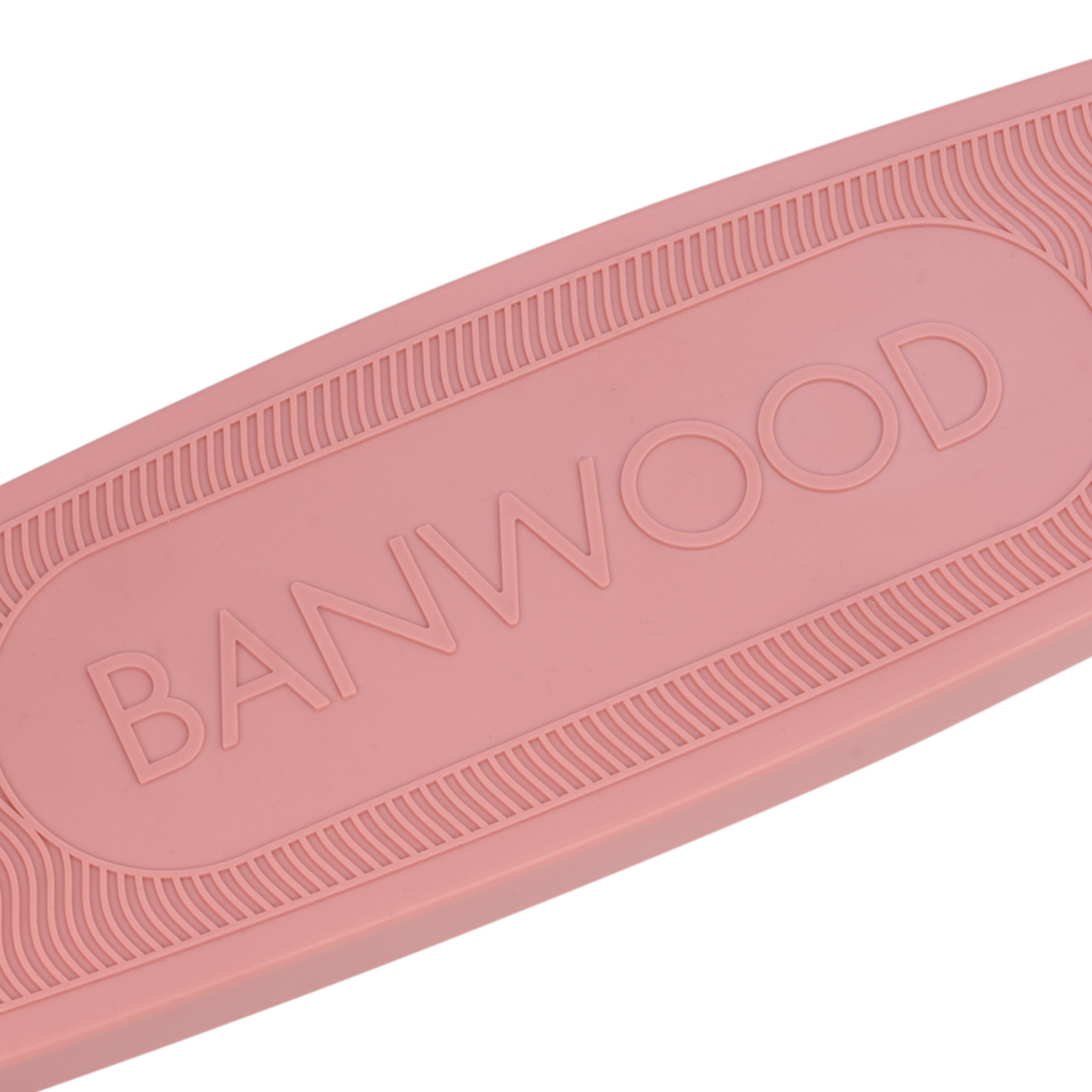 Close-up of a pink Banwood Eco Scooter Raspberry deck with "BANWOOD" embossed in the center, made from recycled plastic for sustainability, and featuring a textured border design.
