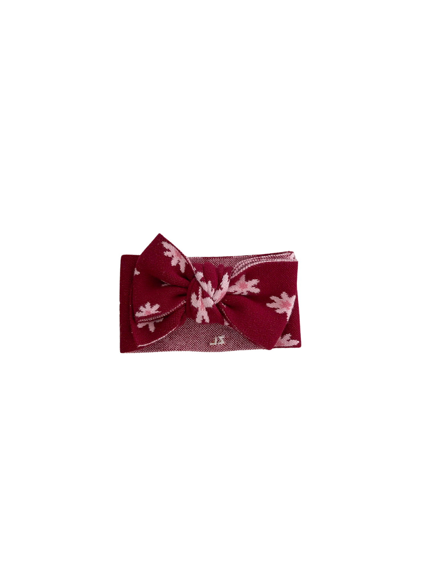 The Ziggy Lou - Headband Lola (Plum) by ZIGGY LOU features a maroon bow with pale pink leaf patterns on a matching elastic band, making it a charming baby accessory, showcased against a black background.