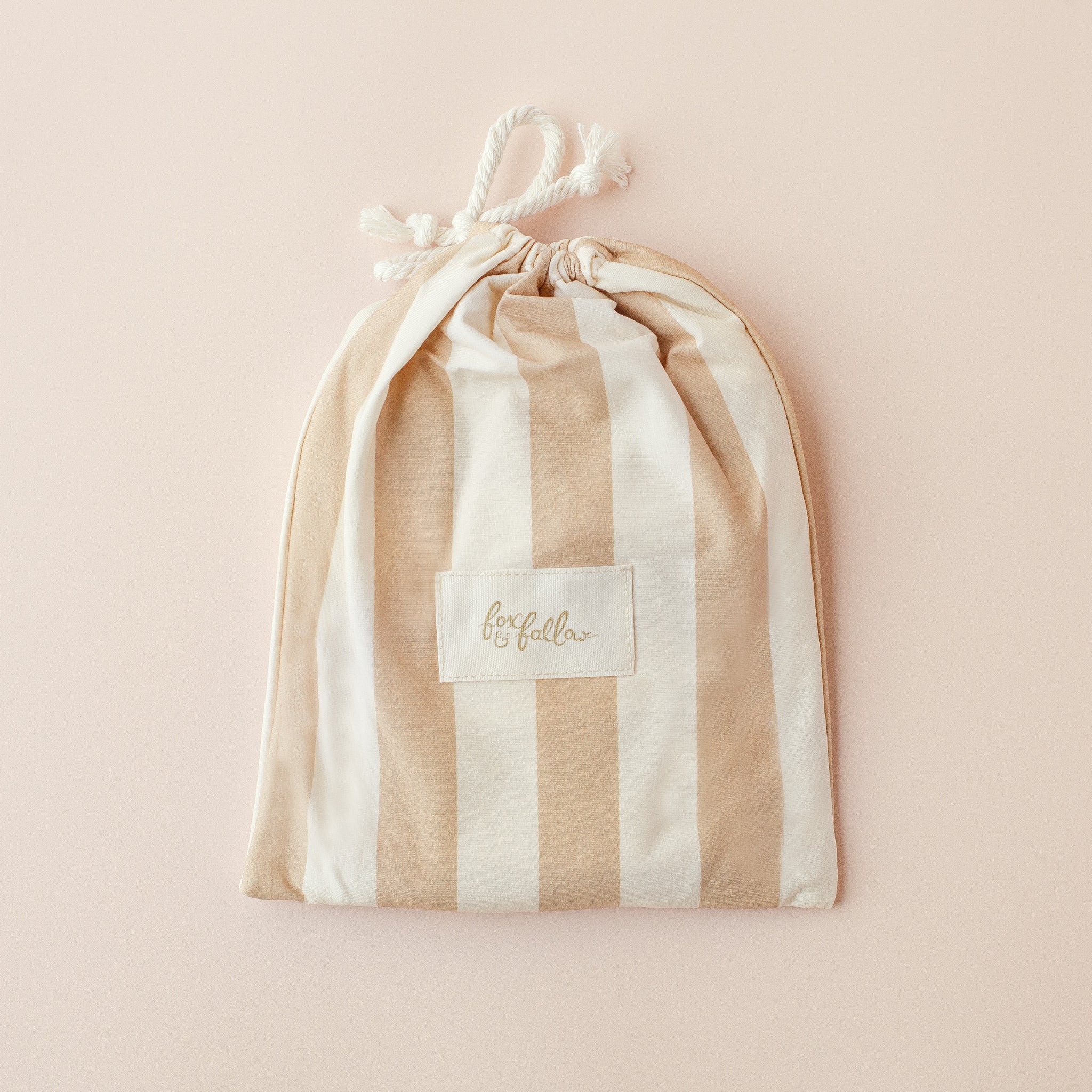 The Fox & Fallow Coffee Stripe Organic Fitted Bassinet Sheet/Change Pad Cover by FOX & FALLOW features beige and white stripes, perfect for a stylish, GOTS certified addition to your baby’s nursery.