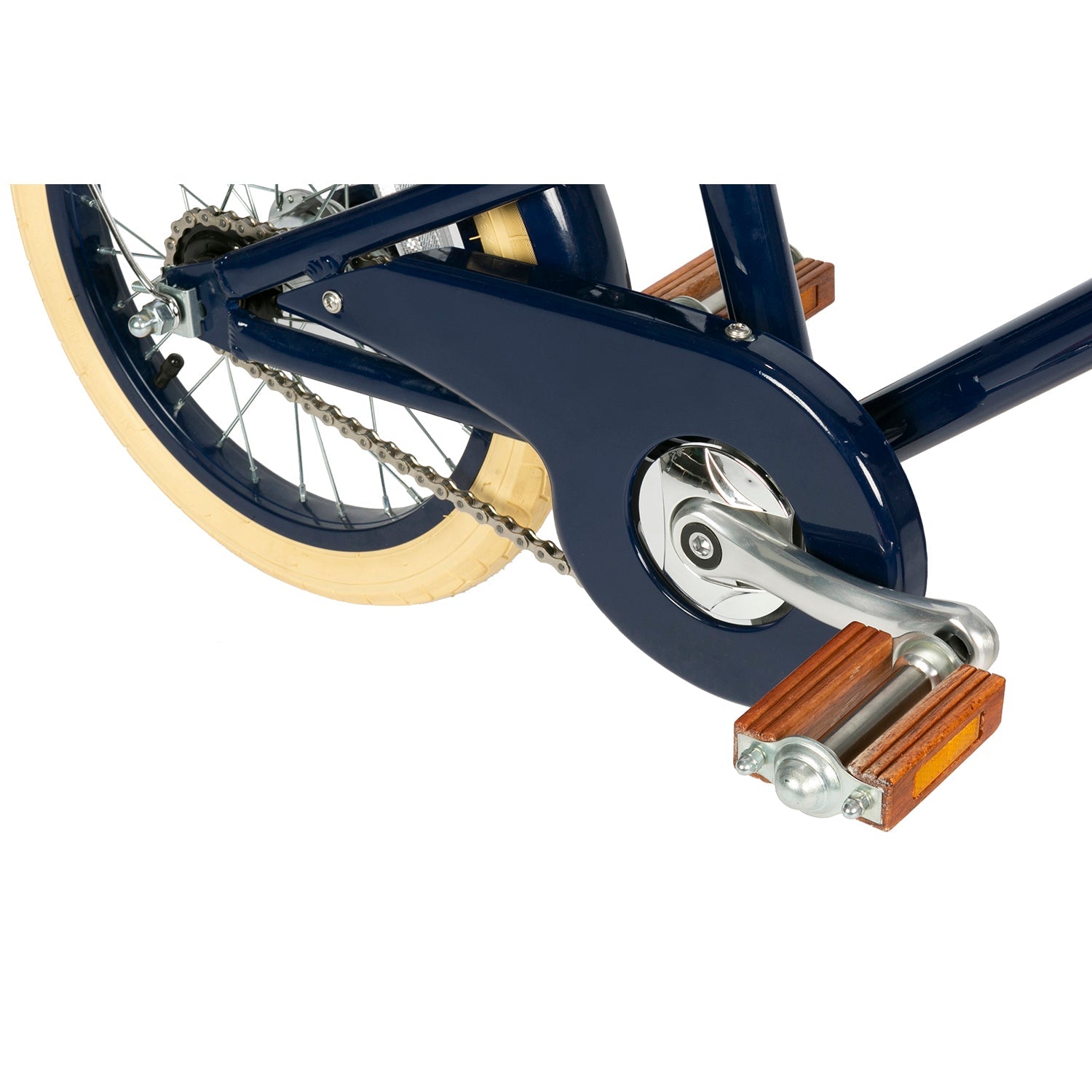A close-up of the rear wheel and pedal of the Banwood - Classic Bicycle Navy showcases a navy blue chain guard, silver crank, and wooden pedal. Its beige tire enhances the vintage style, highlighting BANWOOD's mechanics and design details.