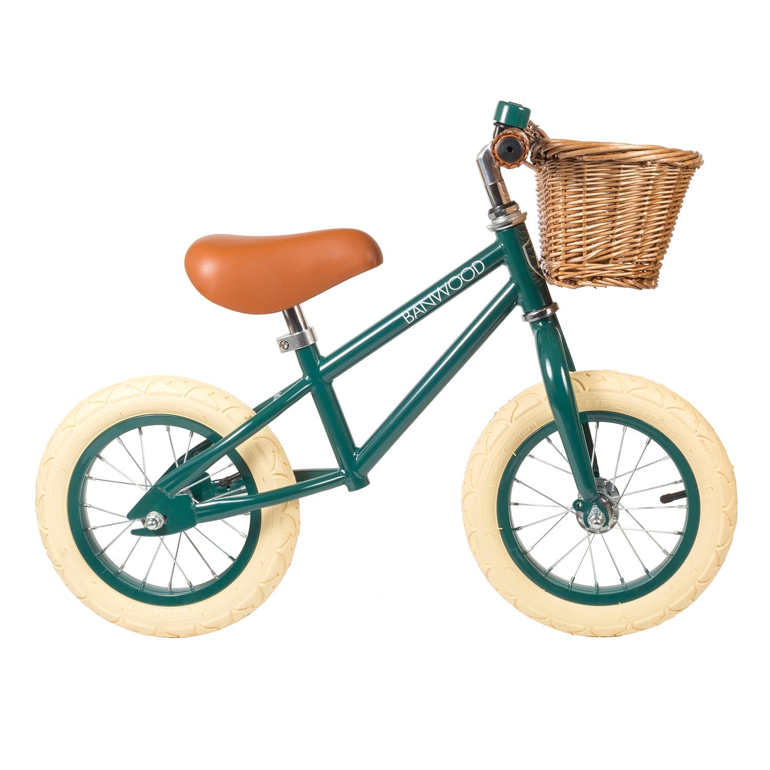 The Banwood - Vintage Balance Bike Dark Green, by BANWOOD, features a vintage design with a child-friendly frame, brown seat, cream-colored tires, and a wicker basket on the handlebars. The frame is proudly labeled "Banwood.