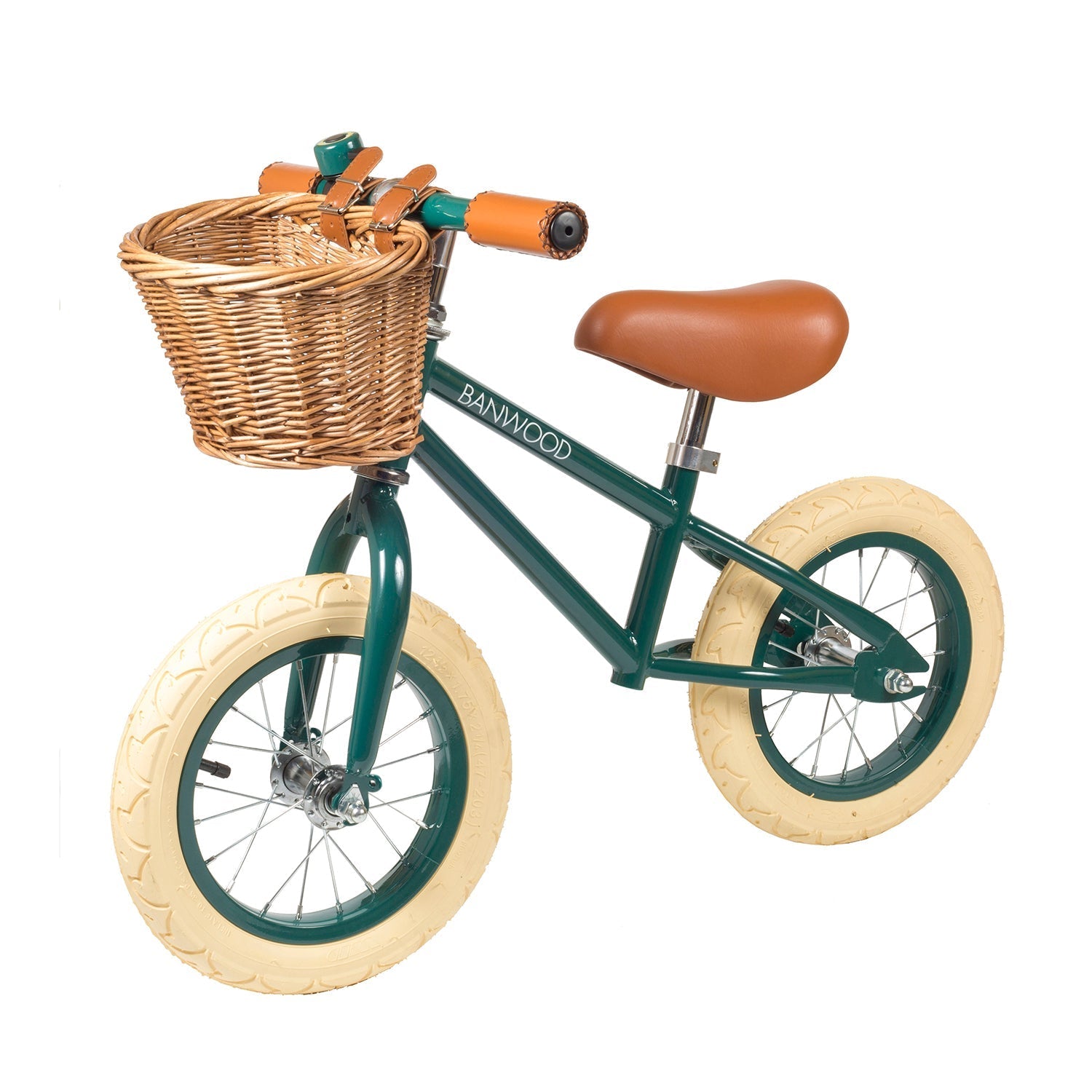 The Banwood - Vintage Balance Bike Dark Green by BANWOOD is a vintage-styled children's balance bike with cream tires, a brown seat, matching handle grips, and a charming wicker basket on the front handlebars.