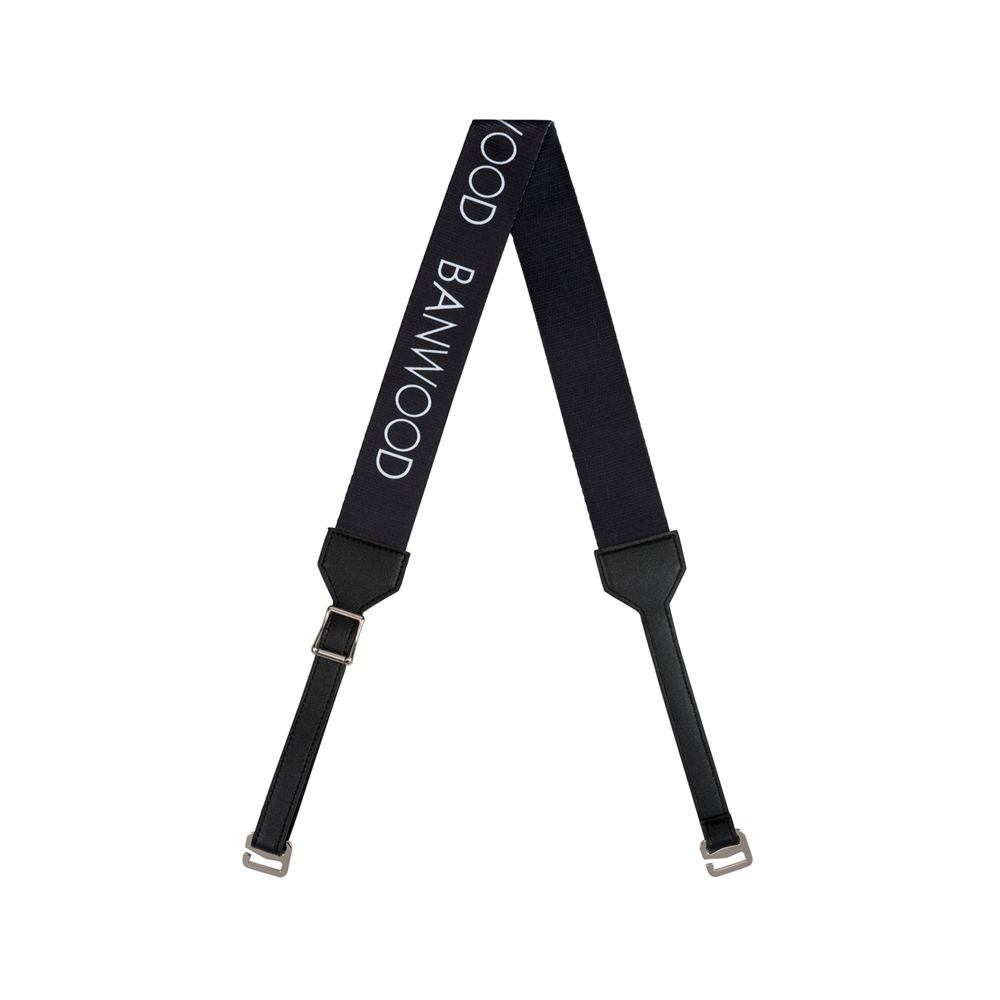 The BANWOOD Carry Strap Black is a sleek strap featuring "BANWOOD" in print. It has silver-toned buckles and leather accents, ideal for stylishly carrying balance bikes or scooters.