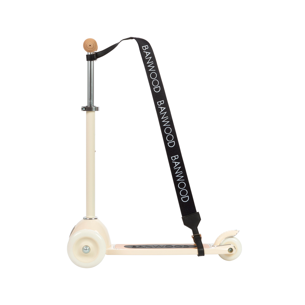 A beige three-wheeled scooter with a Banwood Carry Strap, this chic model features white wheels and a wooden handlebar, perfect for young explorers.