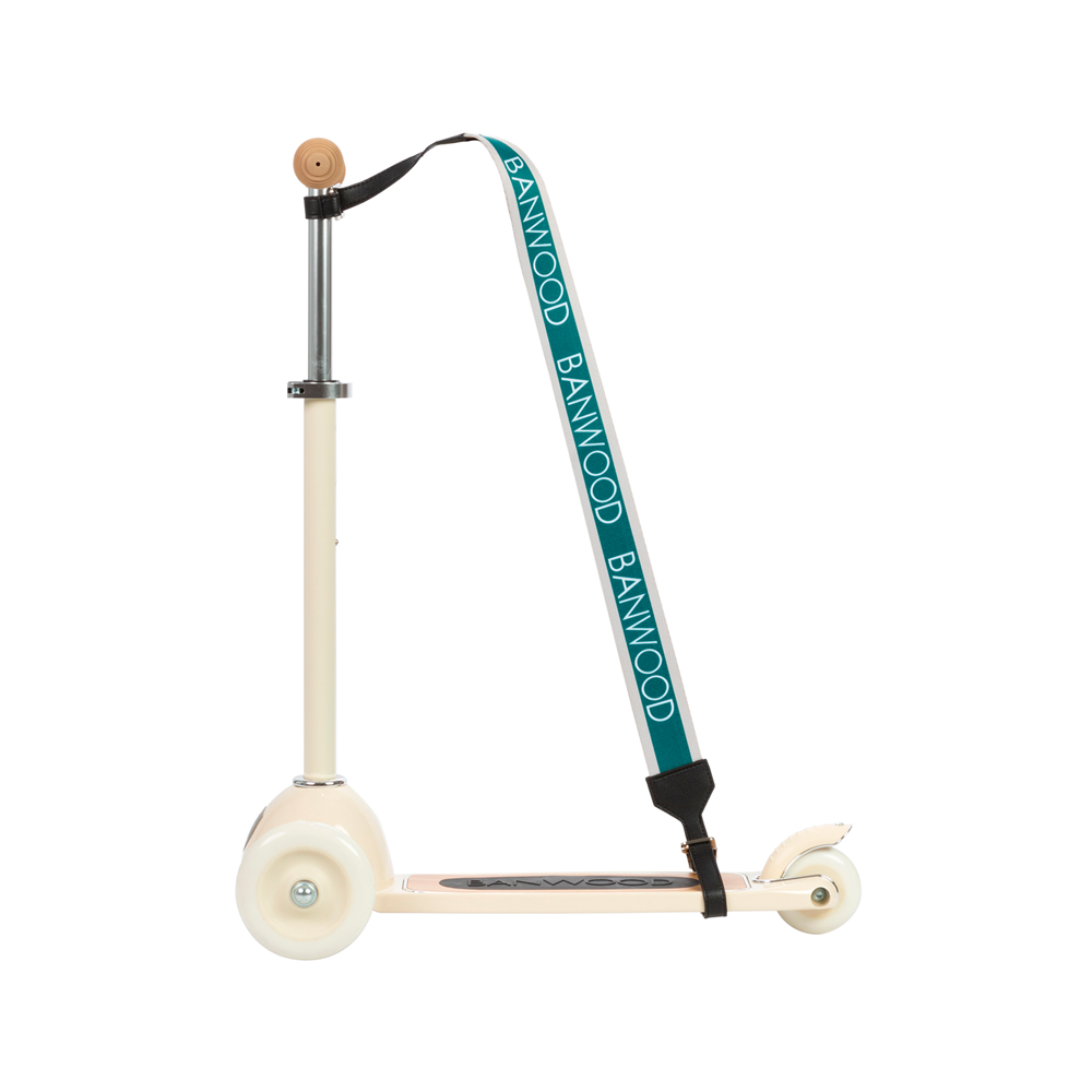 A cream scooter for kids, featuring the Banwood Carry Strap in turquoise, showcases two white front wheels and a single rear wheel. Combining style and function, this chic scooter is elegantly displayed against a clean white background.