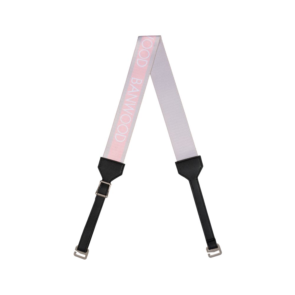 The Banwood - Carry Strap Pink features a detachable pink and grey shoulder strap with black vegan leather ends, silver clasps, and proudly displays "GOOD BANWOOD"—ideal for balance bikes.