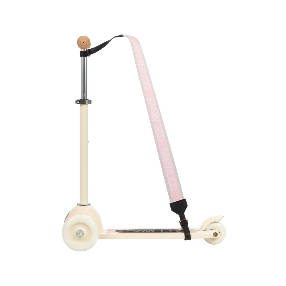 A cream-colored scooter with a sleek, minimalist design and three wheels features a Banwood - Carry Strap Pink, made from vegan leather. The black footboard enhances its style against the white background.