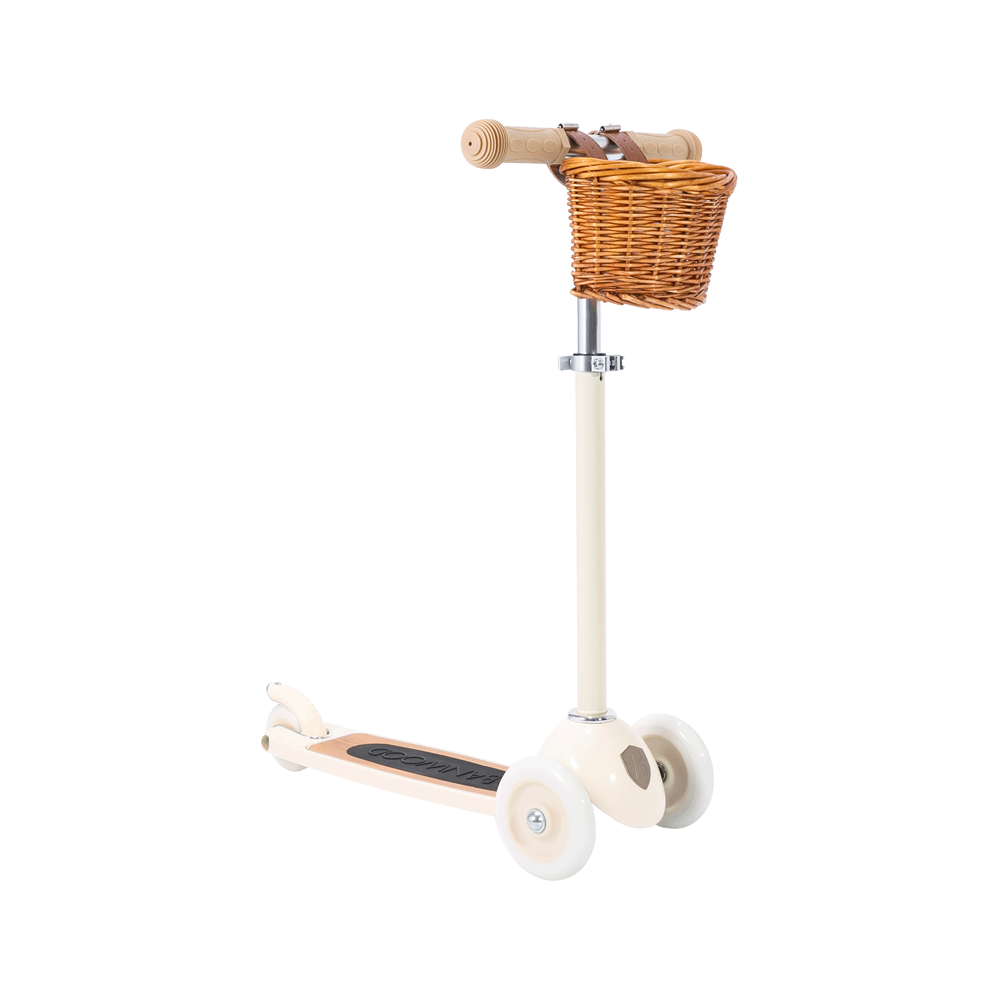 The Banwood - Scooter Cream by BANWOOD is a retro three-wheeled scooter in cream with a small wicker basket on the handlebars, featuring the Easy Ride Steering System for seamless navigation.