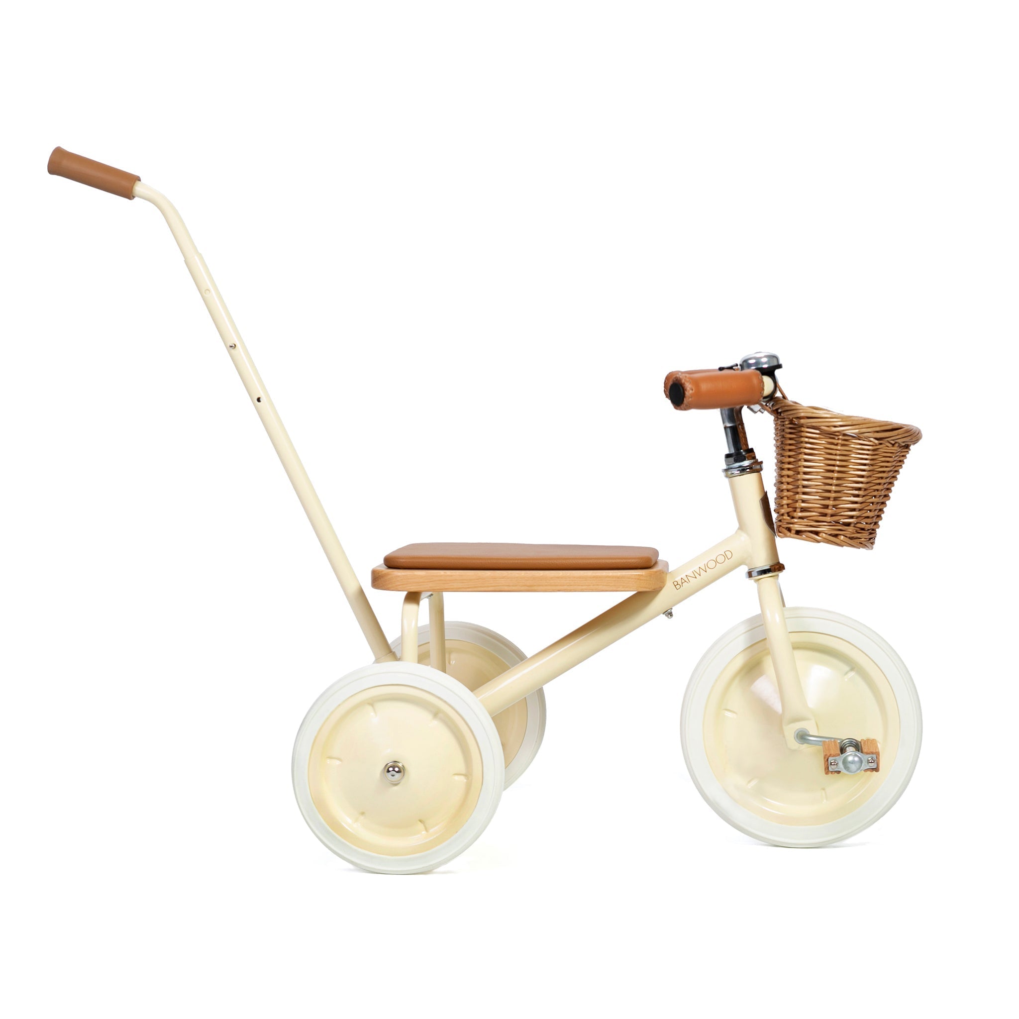 The Banwood - Trike Cream by BANWOOD is a beige tricycle for kids featuring white wheels, a brown cushioned seat, handlebar grips, rear push handle, and a charming front wicker basket with a minimalist and classic design.
