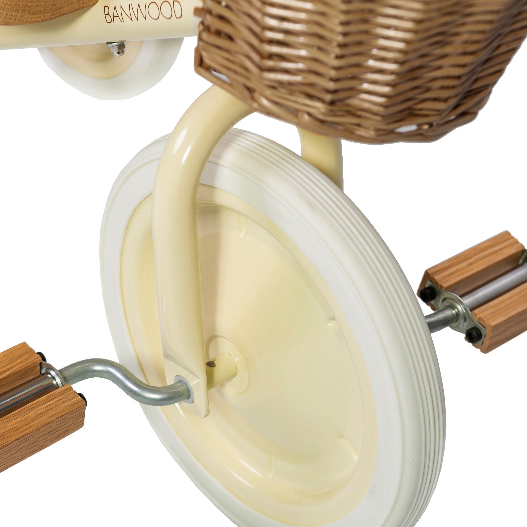 Close-up of the Banwood - Trike Cream, featuring wooden pedals and a charming wicker basket on the handlebars, with part of the BANWOOD brand visible on the frame.