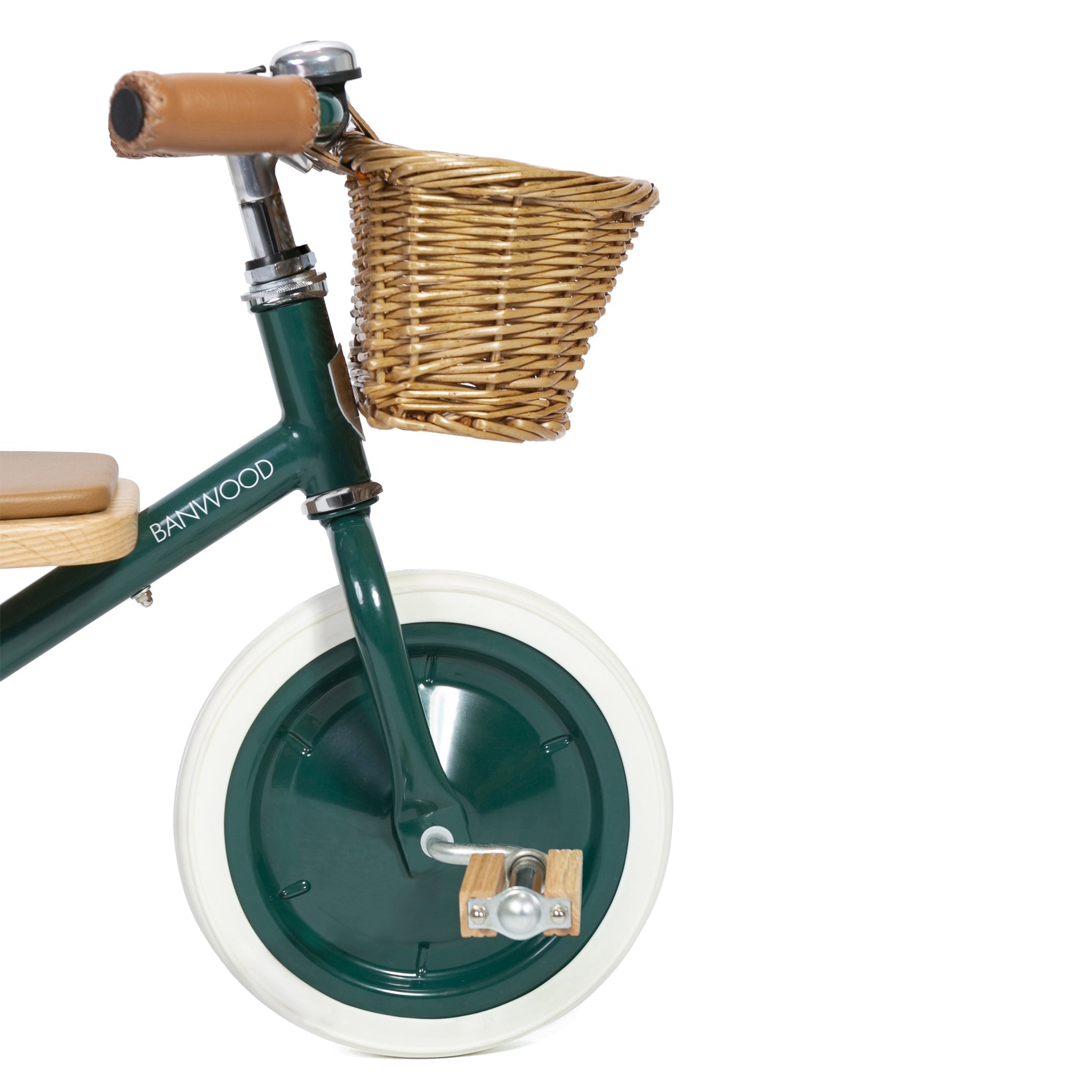 Close-up of the Banwood - Trike Green, a children's balance bike with a front wicker basket and stable design. This charming ride by BANWOOD features a brown seat, handle grips, white front wheel, and visible branding on the frame.