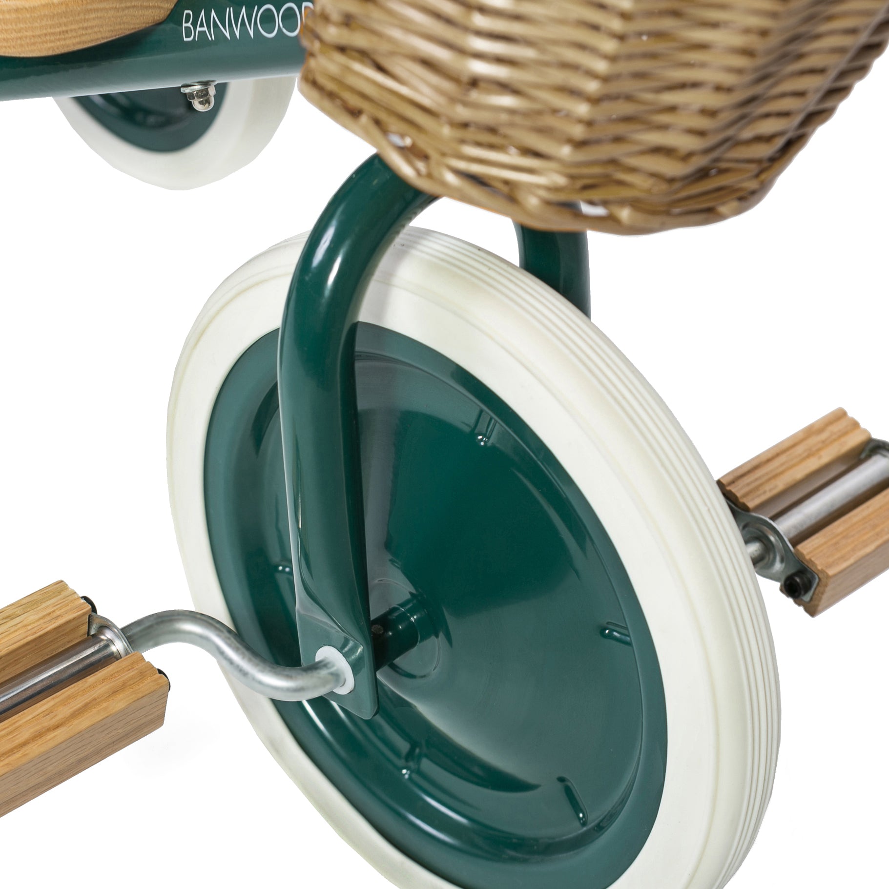Close-up of the Banwood - Trike Green, featuring white tires and wooden pedals. A charming front wicker basket sits above the wheel, ready for adventure. The plain white background highlights every detail of this delightful BANWOOD baby trike accessory.