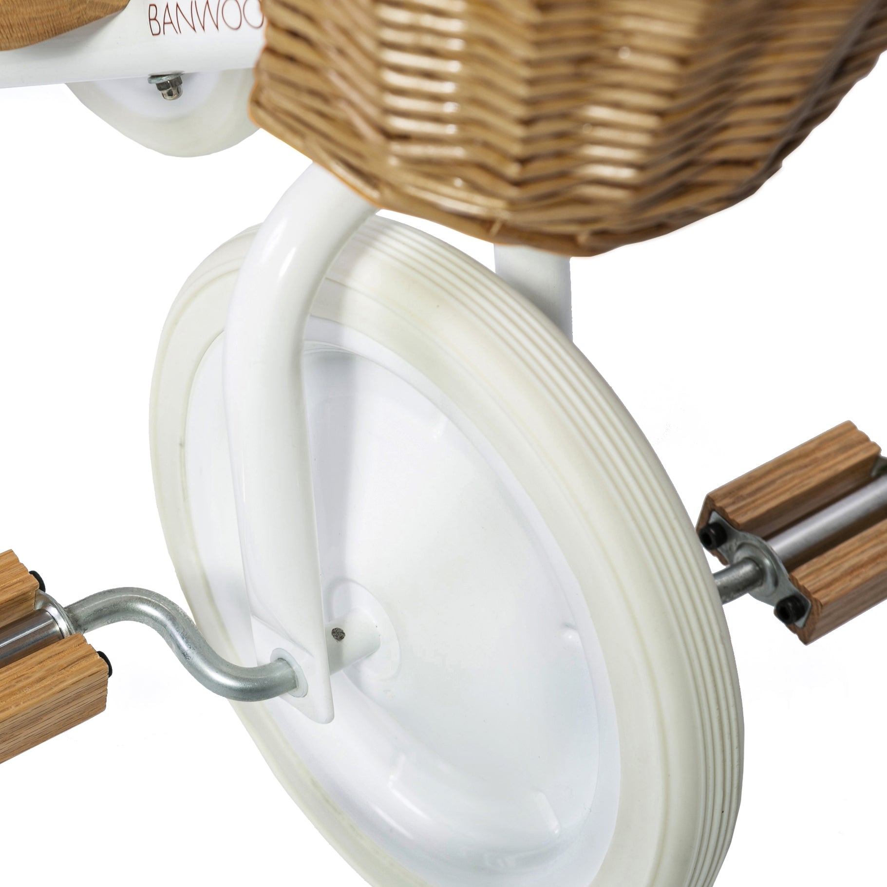 Close-up of the Banwood - Trike White's front wheel with a white rubber tire and fender, plus a wicker basket peeking at the top. Featuring wooden pedals on metal crank arms against a plain white background. This BANWOOD tricycle offers kids a charming and safe design.