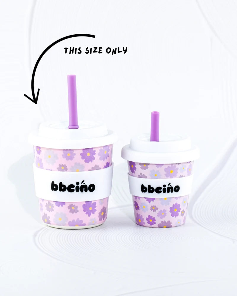 Two purple flower-patterned reusable BBcino cups with straws and white lids are shown. The left cup is larger, with a curved arrow pointing to it and the text "THIS SIZE ONLY" above. Made from sustainably farmed bamboo, BBCINO offers an eco-friendly 240ml BambinoCino Blossom cup for your beverage needs.
