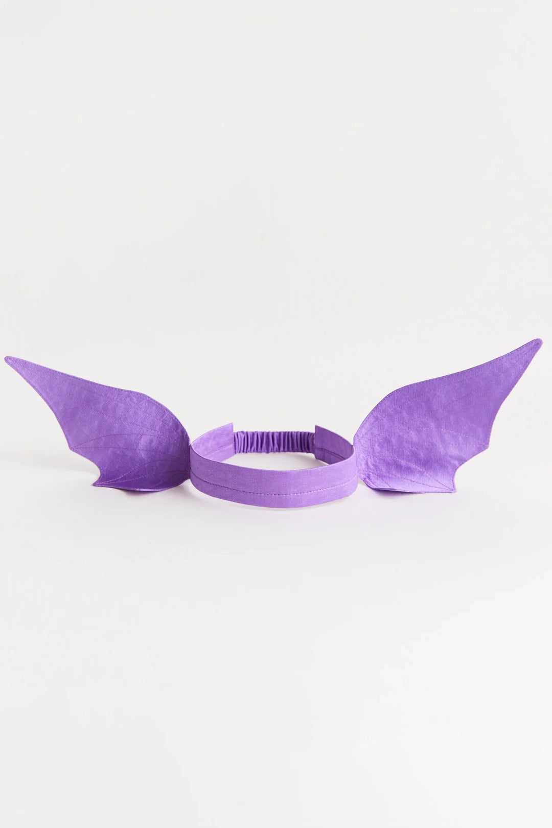 Introducing the Dragon Ears Purple by SARAH'S SILKS—a headband featuring two elongated, wing-like attachments. Perfect for dress-up play, it sits against a plain white background, inviting imagination and open-ended play as it transforms any child into a mystical creature.