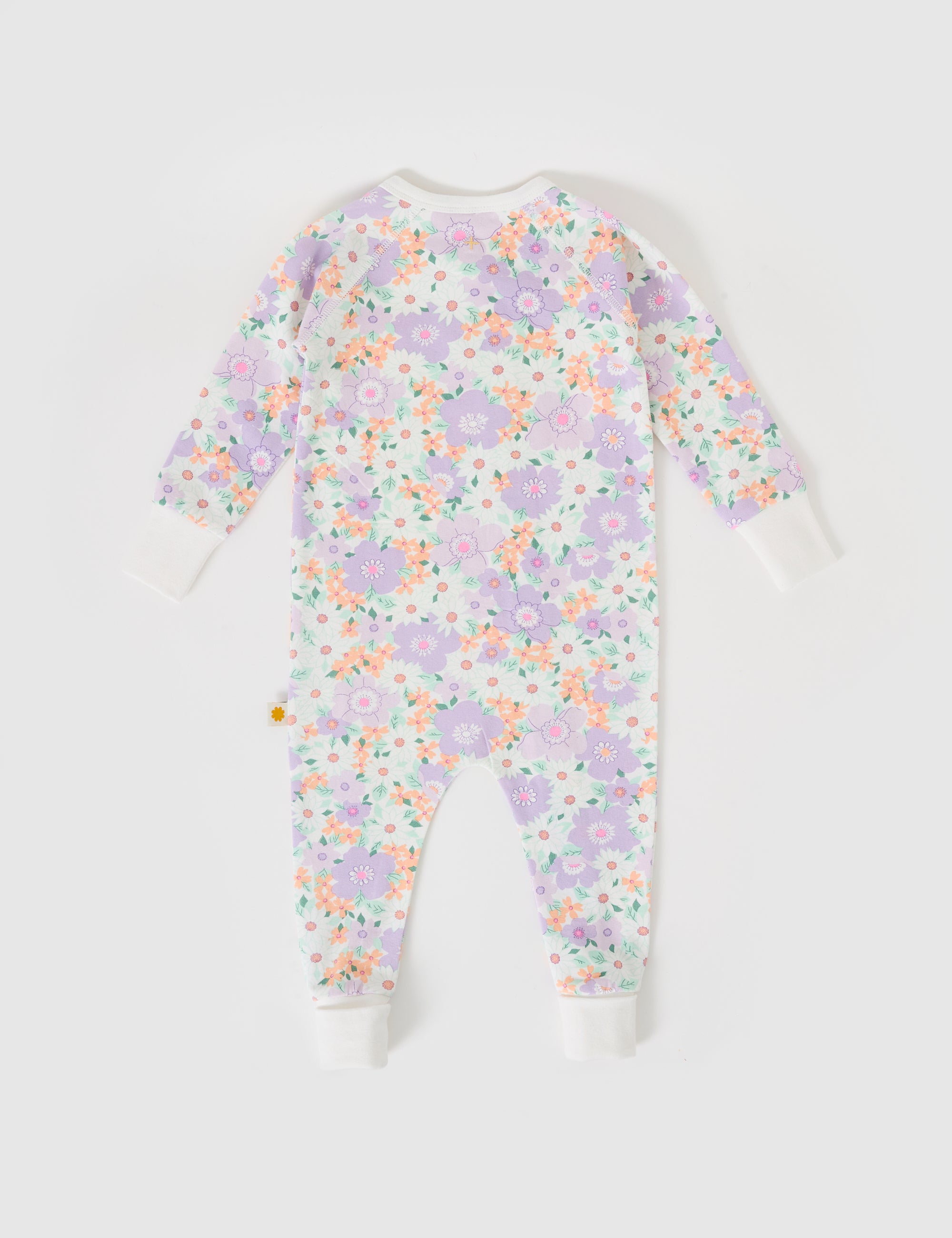 The Goldie + Ace ~ Flora Zipsuit by GOLDIE + ACE is a soft, long-sleeved baby onesie with a vibrant floral print in pink, purple, and orange on white. It features ribbed cuffs and collar for added comfort, set against a plain light gray backdrop.