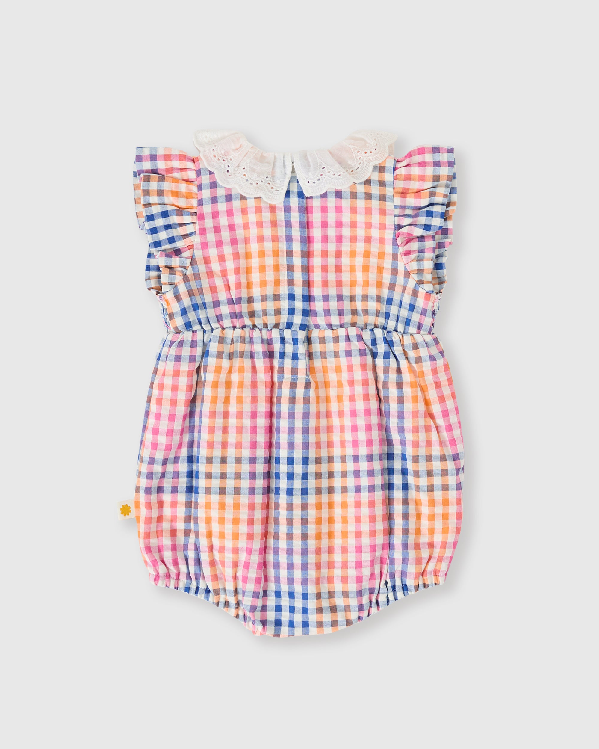 The GOLDIE + ACE Goldie + Ace - Rainbow Gingham Lani Smocked Romper features a vibrant pink, orange, blue, and white plaid pattern with ruffled sleeves and a broderie anglaise collar, shown against a plain light gray background. Perfect for special occasions.