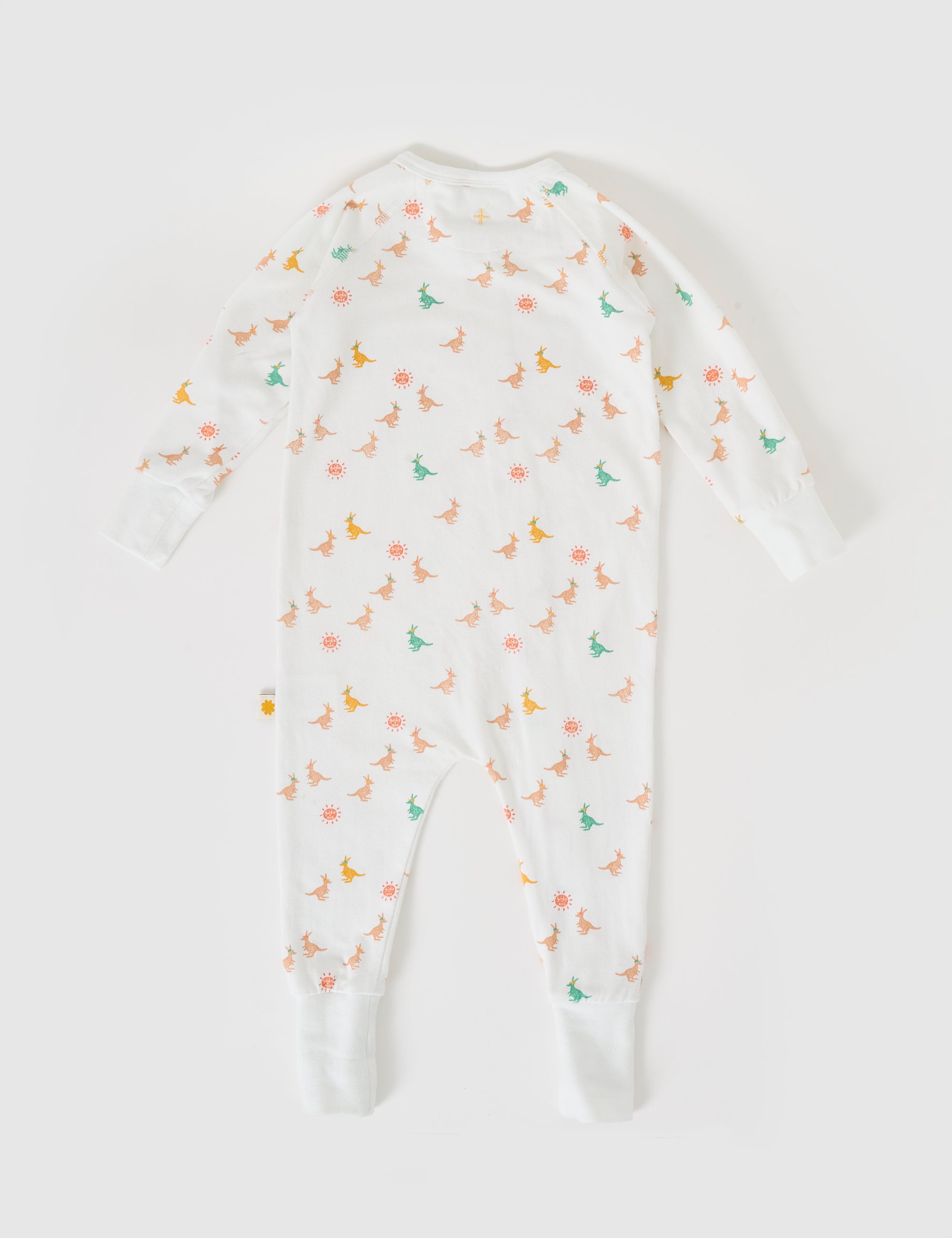 The Goldie + Ace Joey Zipsuit by GOLDIE + ACE is a white onesie with green and orange dinosaur and cheerful orange sun prints. It features long sleeves with extendable ribbed cuffs at the ankles and wrists, offering a playful, comfortable design for growing infants.
