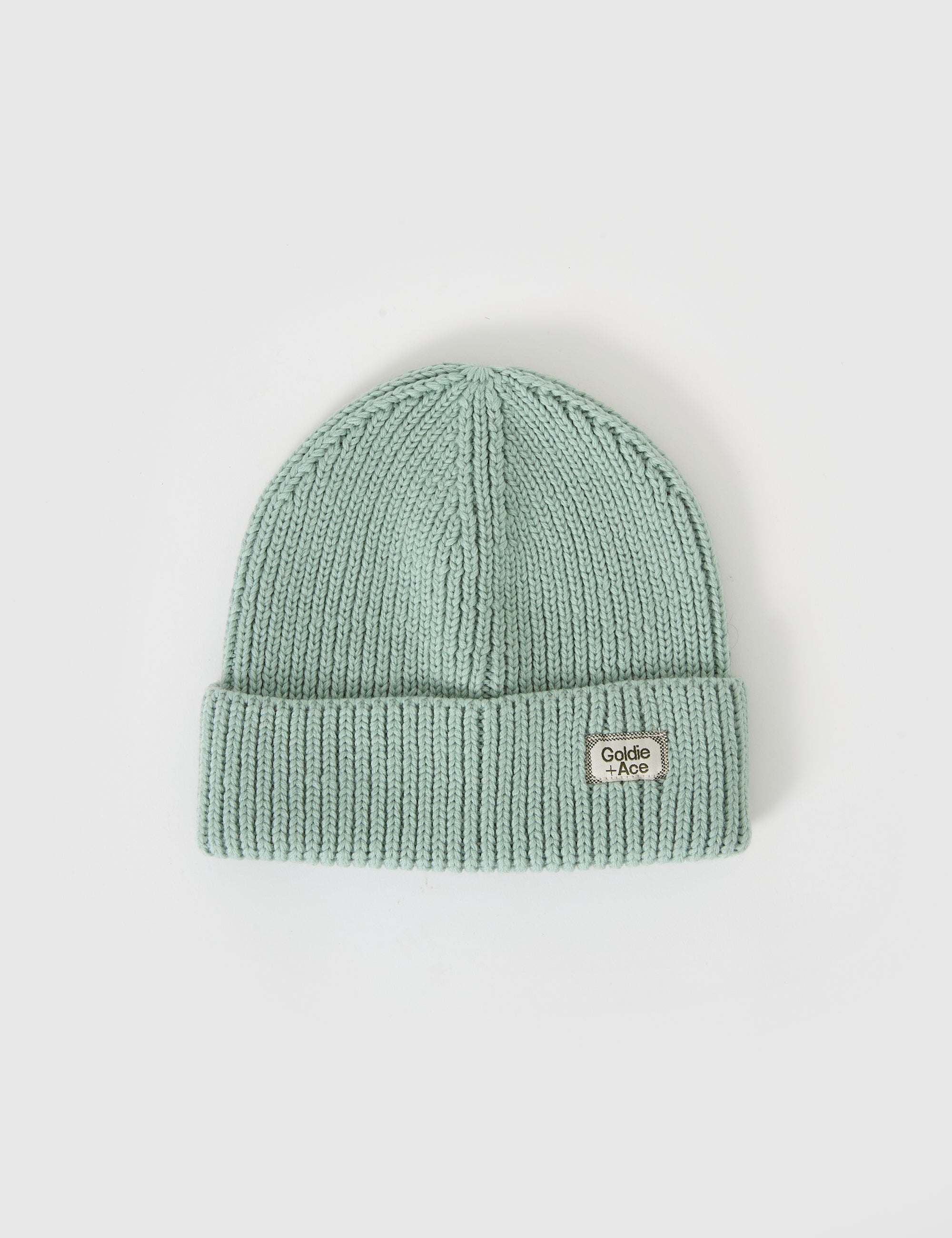 The mint rib knit beanie "Wool Beanie Mint" by GOLDIE + ACE features a folded brim and a small oval badge that reads "Cecilie Bahnsen" in black, made of merino wool, displayed on a plain white background.