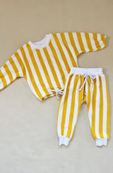 Yellow striped top and bottom set flat laid on grey background
