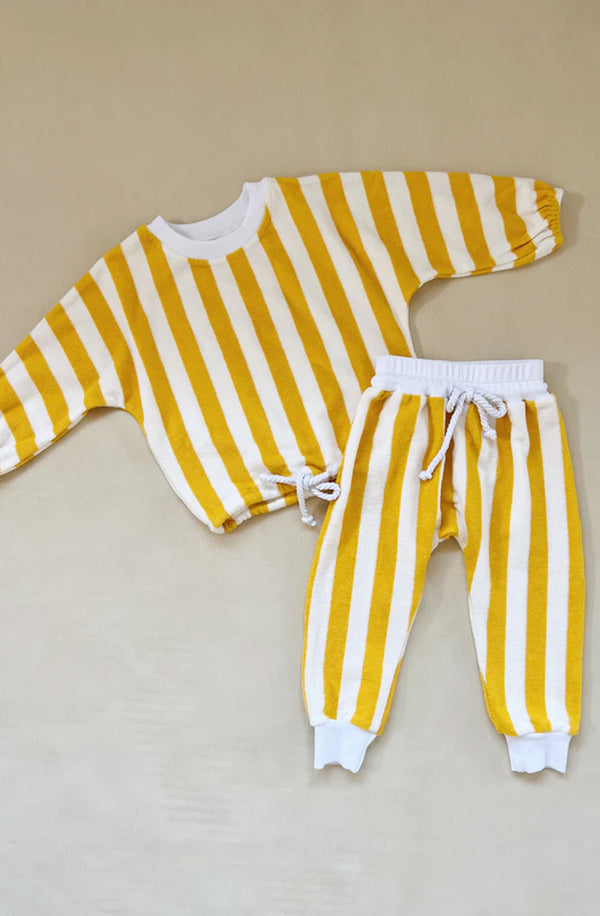Yellow striped top and bottom set flat laid on grey background