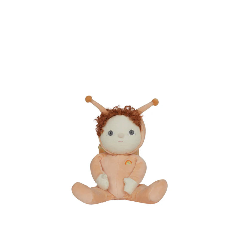 The OLLI ELLA Dinky Dinkum Scottie Snail is a soft plush toy with curly brown hair, an orange onesie with antennae, and a rainbow chest patch, shown sitting upright against a white background.