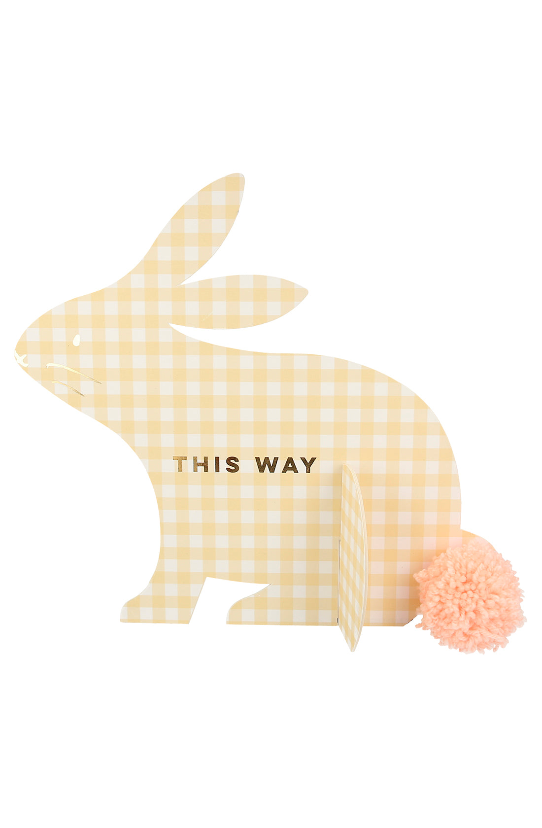 The Gingham Bunnies Egg Hunt Kit by MERI MERI includes a charming bunny-shaped cutout adorned with yellow gingham print, "THIS WAY" in gold foil, a fluffy pink pom-pom tail, and a small stand for support—perfect for any egg hunt setup.