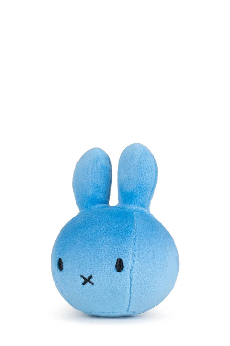 The BON TON TOYS X MIFFY Miffy Squish Ball Blue is a small, round plush featuring a minimalist blue bunny with long upright ears, black stitched eyes, and an "X"-shaped mouth—ideal for stress relief. Shown on a plain white background.