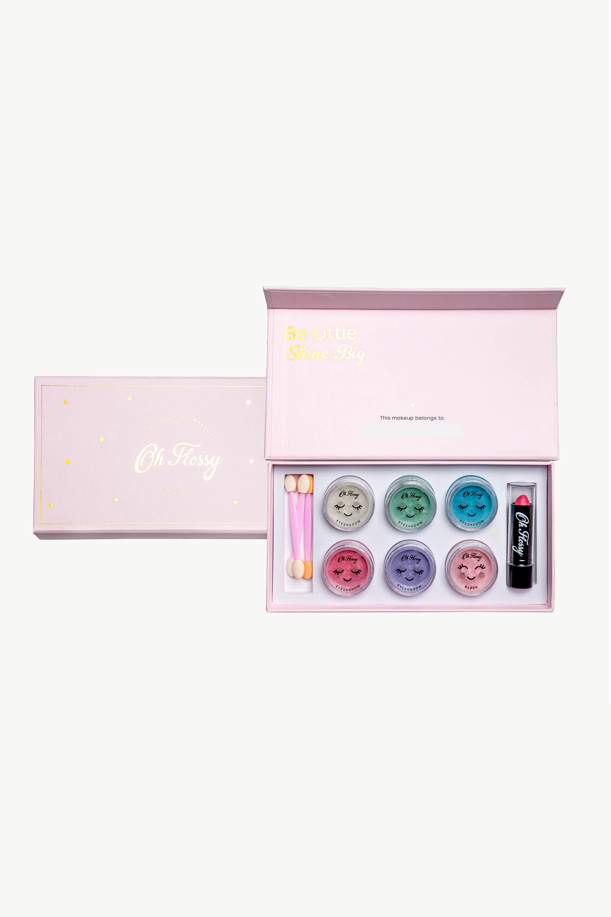 The Oh Flossy Deluxe Makeup Set by OH FLOSSY includes a pink box with six containers of colorful, non-toxic eyeshadow, two dual-ended applicators, and a kid-friendly black lipstick. The lid reads "Oh Hissy" in gold, ideal for safely introducing kids to natural cosmetics.