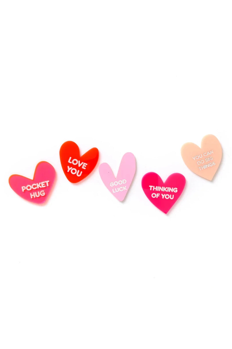 The HELLO KIT CO Pocket Love Heart Set features five colorful heart-shaped pins, each with a message—POCKET HUG, LOVE YOU, GOOD LUCK, THINKING OF YOU, and YOU CAN DO BIG THINGS—lined up on a white background.