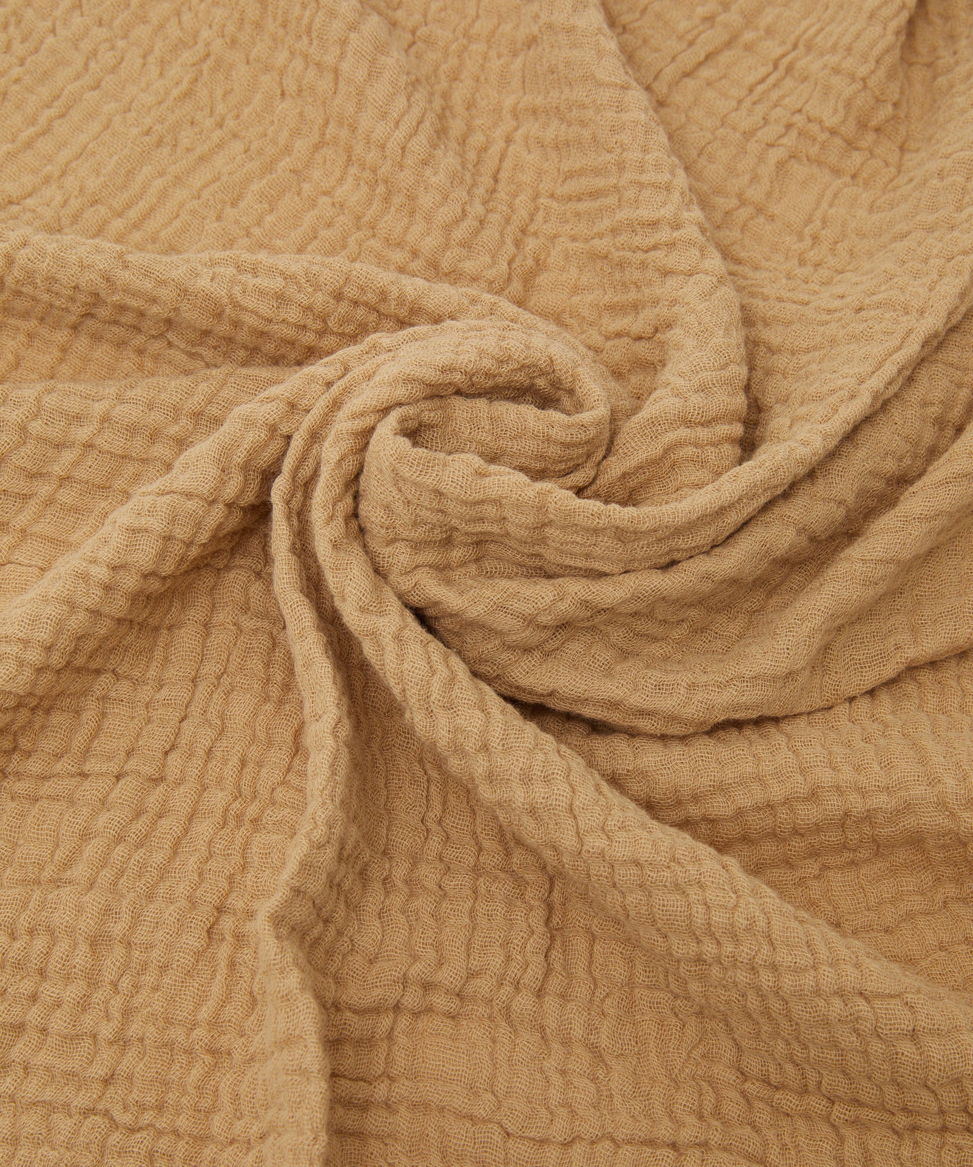 Philé - Swaddle Cacao by PHILÉ features soft, crinkled Oeko-Tex certified cotton in a cacao beige shade, arranged in gentle spiral folds for a cozy, tactile look.