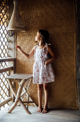Girl standing in Balinese hut wearing the Luna Pinafore