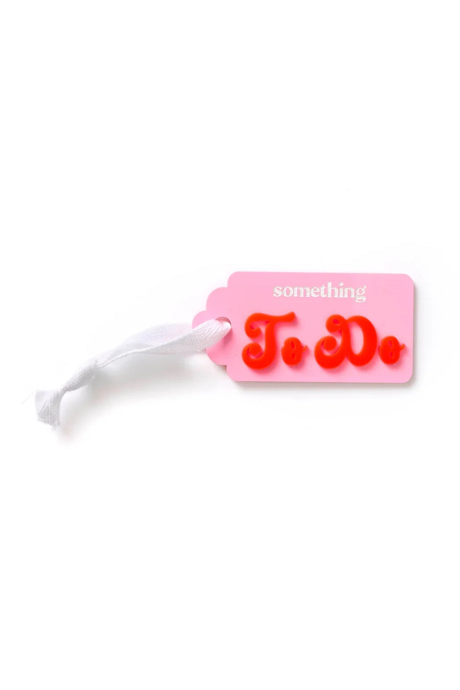 The Something TO DO Tag Pink/Red by HELLO KIT CO is a charming pink acrylic tag adorned with a white ribbon and the phrase "something To Do" in vibrant letters, making it an ideal gift. The words "To Do" are highlighted in bold, red script.