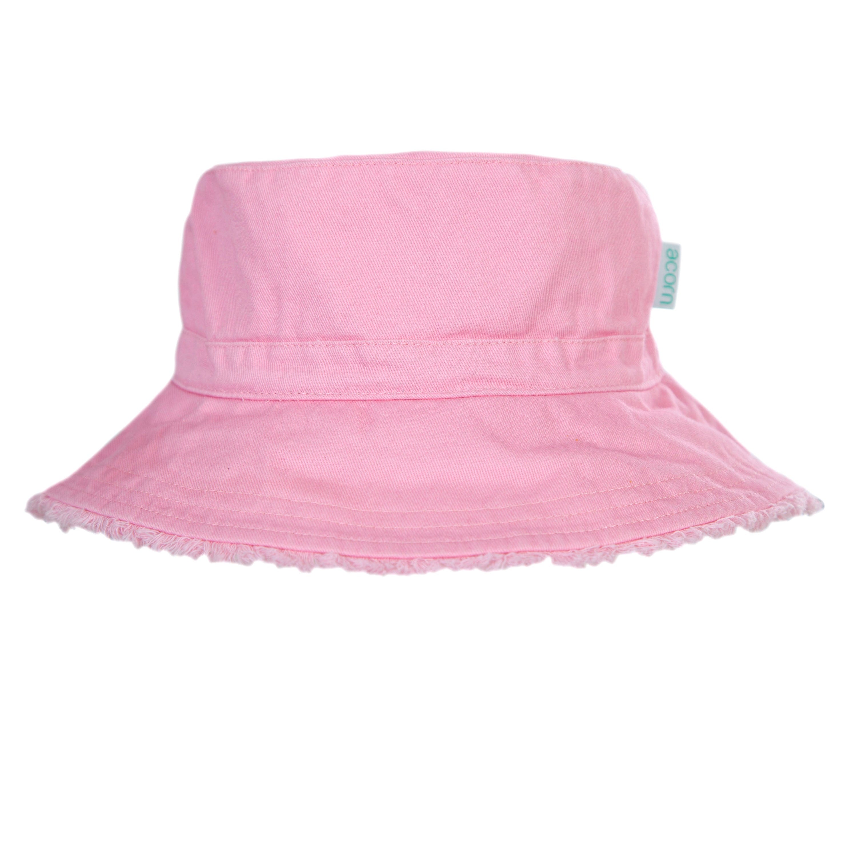 The Frayed Bucket Hat Strawberry by ACORN KIDS is a pastel pink bucket hat made from Cotton Twill with a wide brim that provides UPF50+ sun protection. It includes a subtle, matching band around the crown and a small, off-white tag on the side. The brim's edge is slightly frayed, giving it a casual, worn-in appearance.