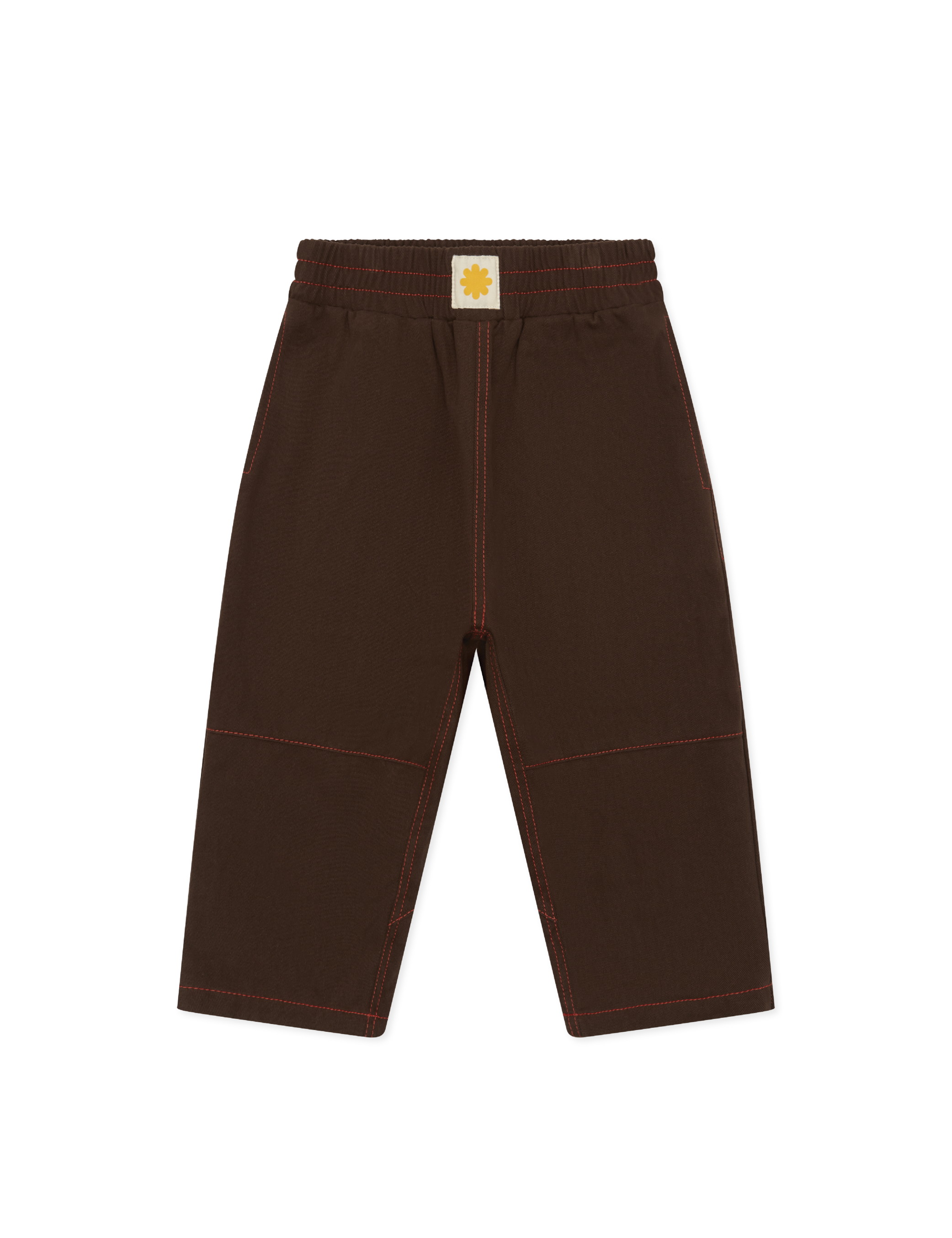The Sonny Label - Cargo Pants by SONNY LABEL are brown cotton twill with red stitching, an elastic waistband, a white square tag with a yellow flower, straight loose legs, and visible seam details.