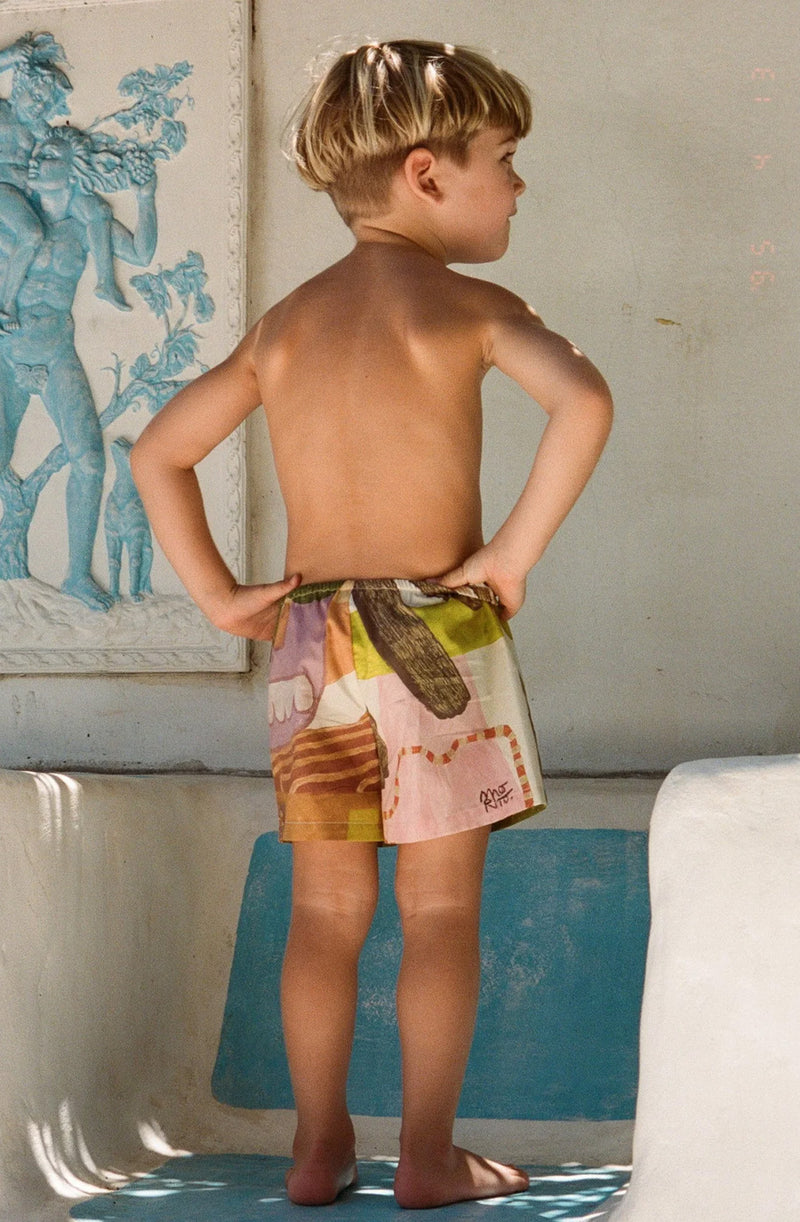 Boy standing facing backwards with hand on hips wearing the Bajo La Palma shorts