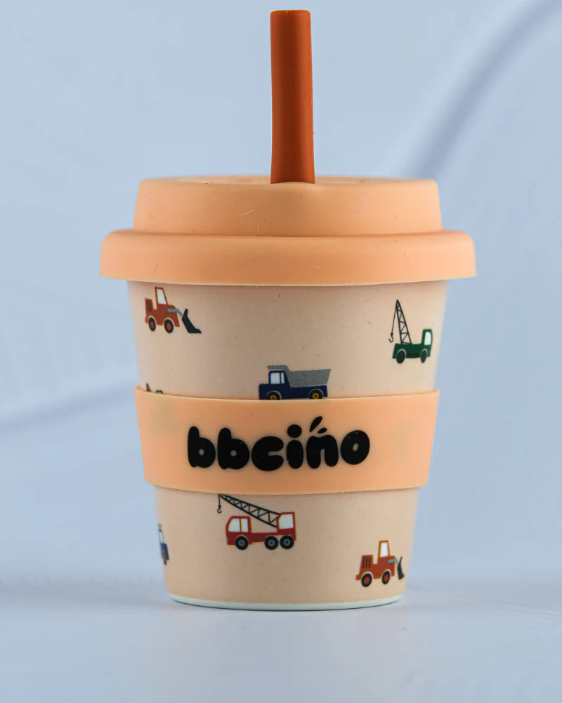 The BBCINO - Reusable Babycino Cup 120ml Truck That features construction vehicle illustrations, an orange lid and straw, a peach band with "bbcino," and is crafted from sustainable bamboo.