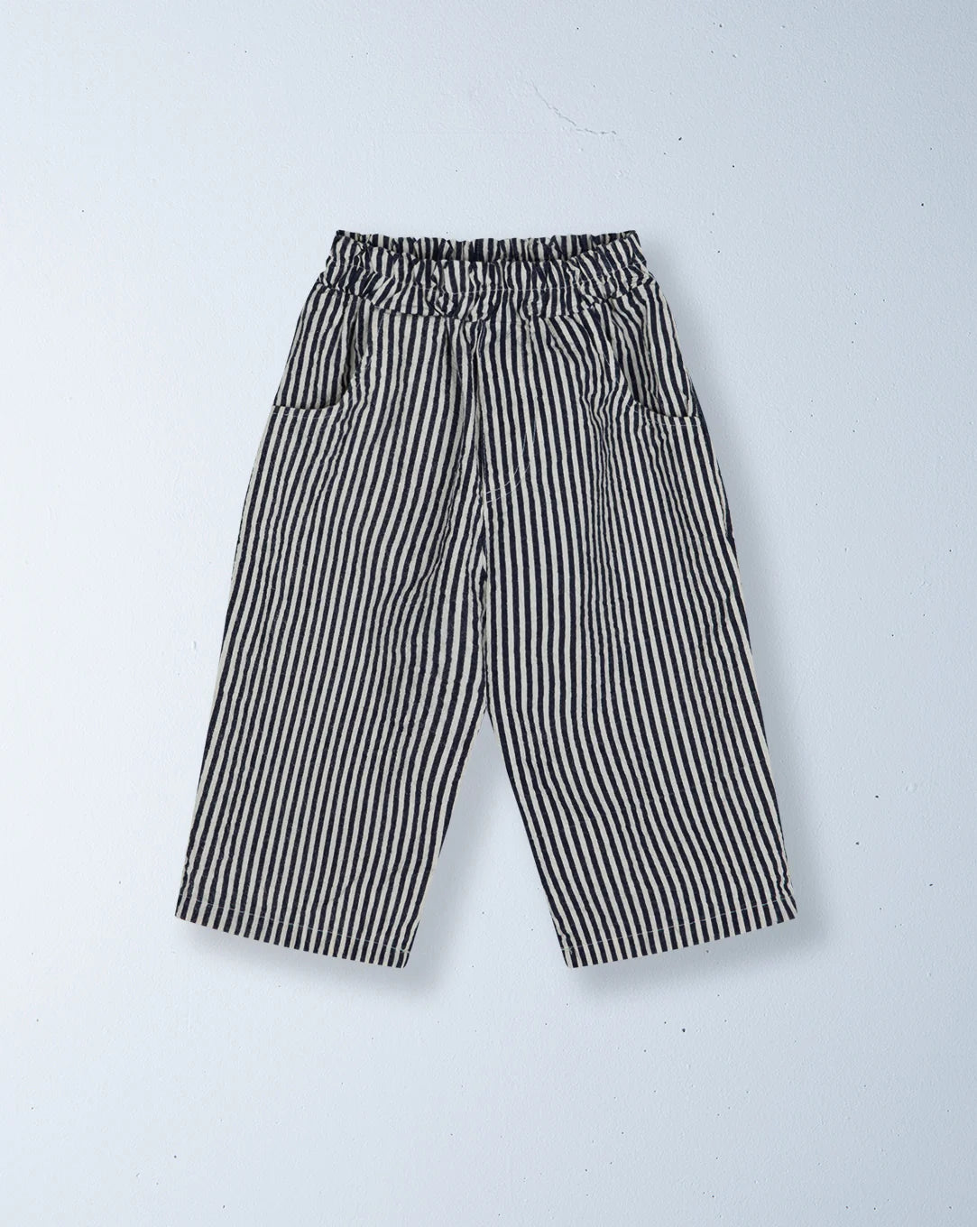 The ZIGGY ZAZA Ziggy Zaza - Casper Pant Navy Stripe features a relaxed fit, wide-leg cotton design with black and white vertical stripes, an elastic waistband, and side pockets, shown flat on a light background.