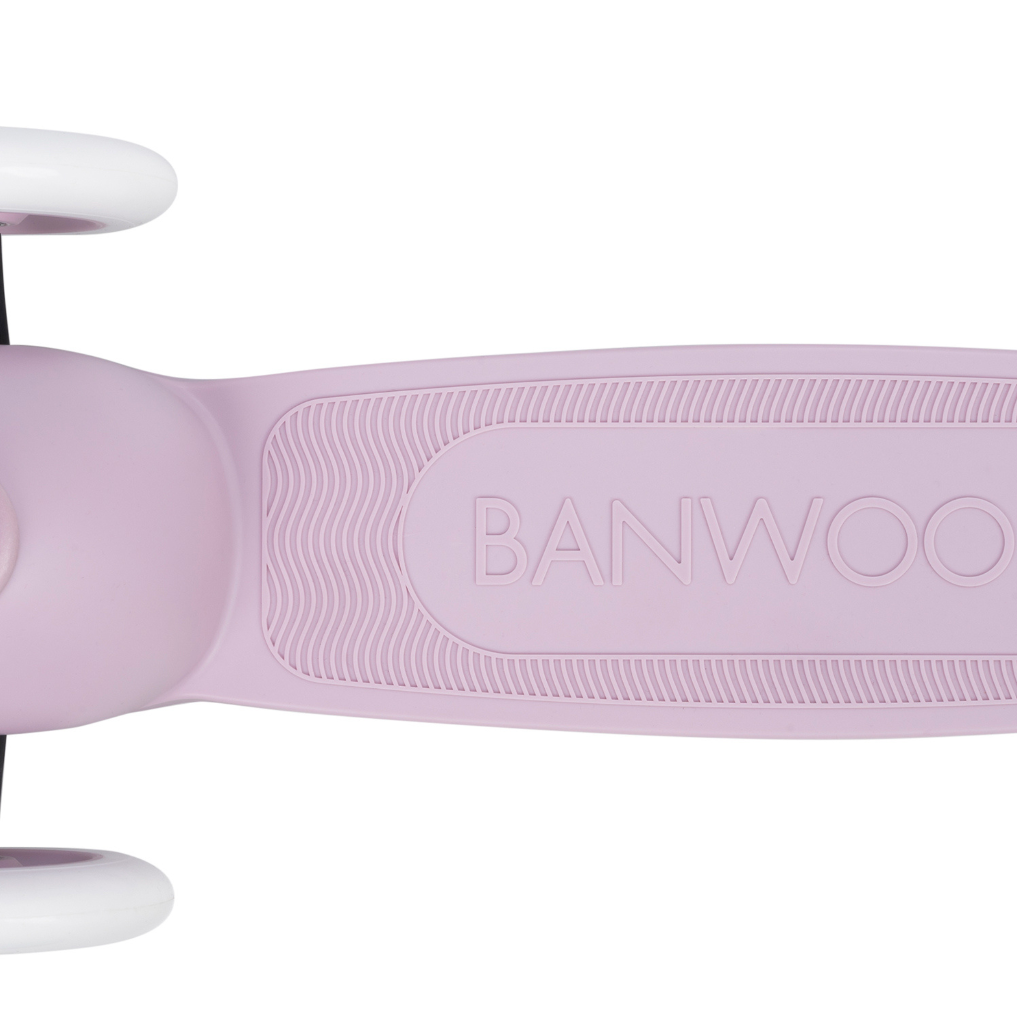 A close-up of the lavender deck on the Banwood Eco Scooter showcases "BANWOOD" embossed on it. Made from recycled plastic, the deck features textured grip lines. The image elegantly displays part of the white front and rear wheels against a pristine white background.