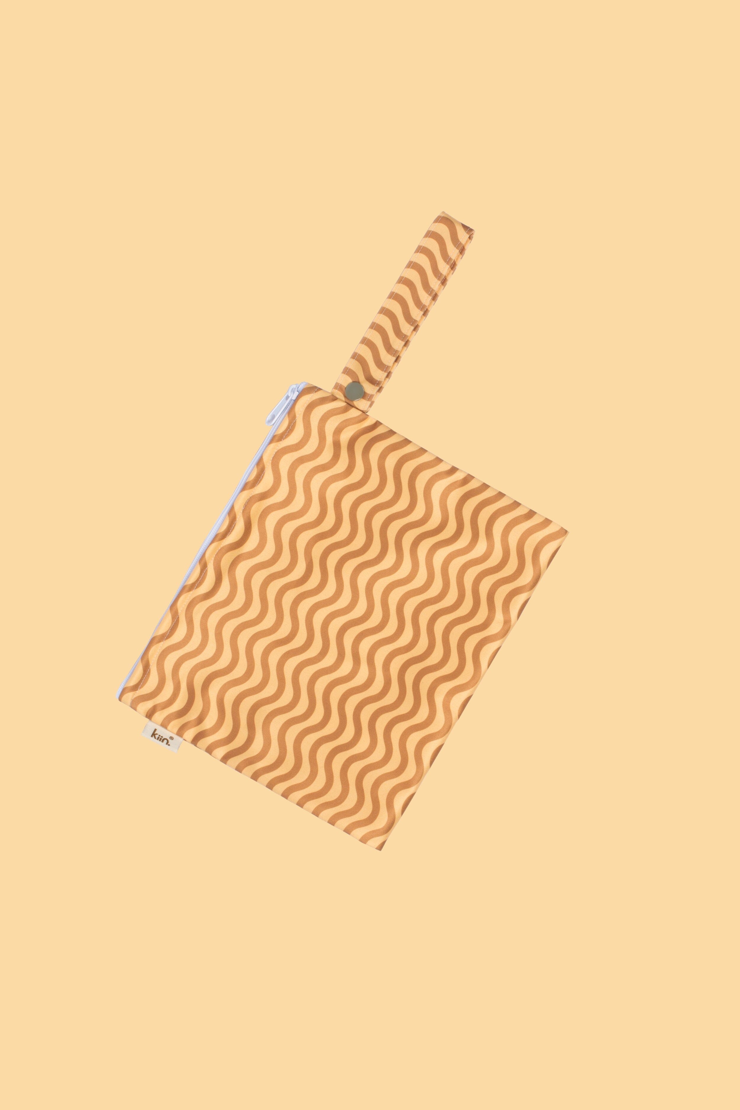The KIIN BABY Reusable Wet Bag Flower Power is an eco-friendly pouch with a wave pattern in brown and tan, featuring a matching handle on one side, set against a plain beige background.
