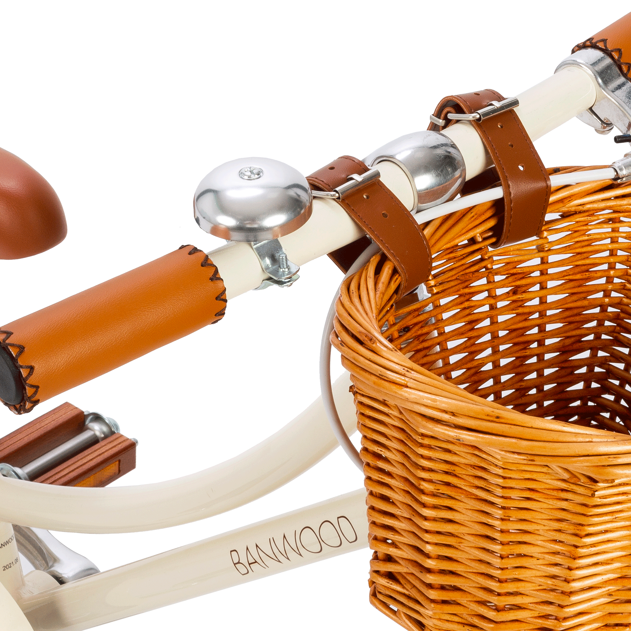 A close-up of the Banwood - Classic Bicycle Cream handlebar shows a brown leather grip, vintage-style silver bell, and a wicker basket with leather straps. The essence of Scandinavian design is captured elegantly on the BANWOOD-branded bike frame.