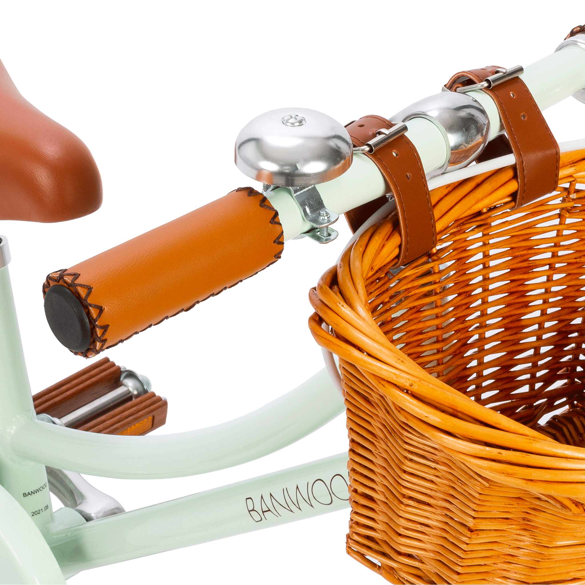 Close-up of bicycle handlebars with brown leather grips and a metal bell attached. A wicker basket is secured with matching leather straps. The Banwood - Classic Bicycle Pale Mint captures Scandinavian design with its light green frame, exuding vintage charm from the renowned brand BANWOOD.